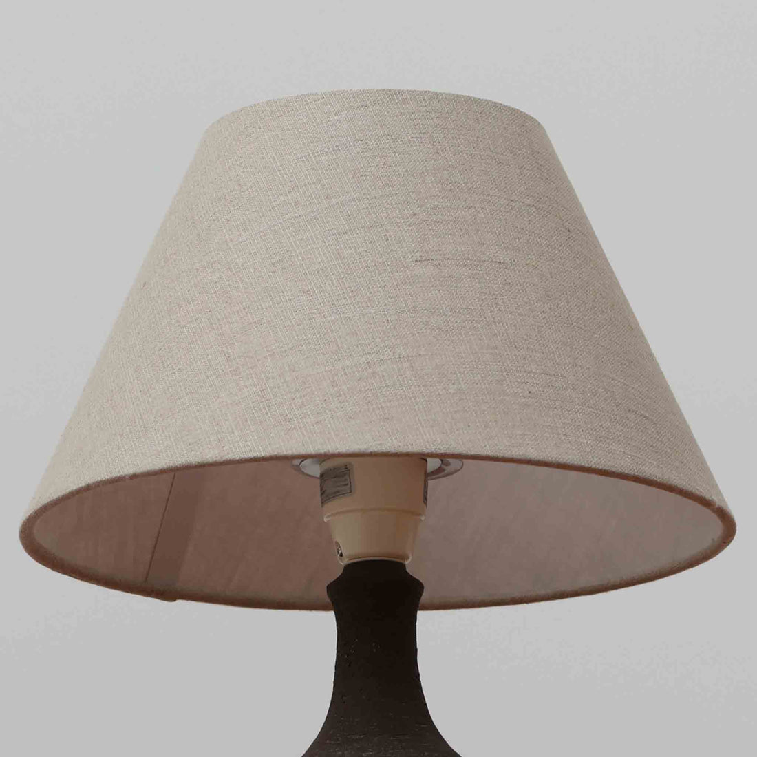 Chris HaslevがJetiのために手掛けたこちらのテーブルランプは、太陽を思わせるレリーフ模様をまとった陶器ベースと、素朴な土肌と釉薬の濃淡が織りなす豊かな表情が魅力で、コンパクトながら存在感を放つ北欧ビンテージ品です。上部のマットな質感が造形を引き締め、リネンシェード越しに広がるあたたかな灯りが空間をやさしく包み込み、リビングやベッドサイドのアクセントとして取り入れやすい一台に仕上がっています。