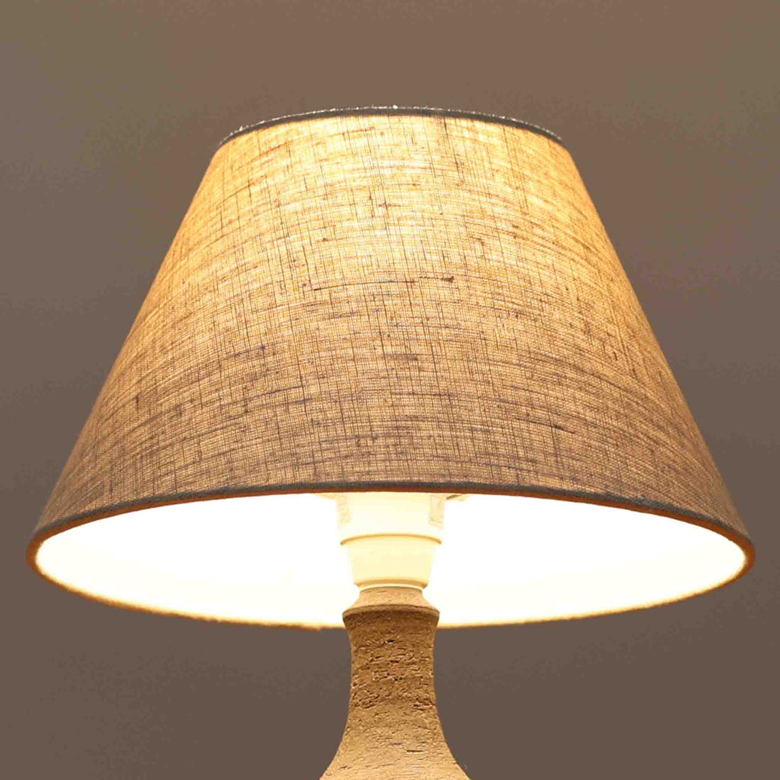 Chris HaslevがJetiのために手掛けたこちらのテーブルランプは、太陽を思わせるレリーフ模様をまとった陶器ベースと、素朴な土肌と釉薬の濃淡が織りなす豊かな表情が魅力で、コンパクトながら存在感を放つ北欧ビンテージ品です。上部のマットな質感が造形を引き締め、リネンシェード越しに広がるあたたかな灯りが空間をやさしく包み込み、リビングやベッドサイドのアクセントとして取り入れやすい一台に仕上がっています。