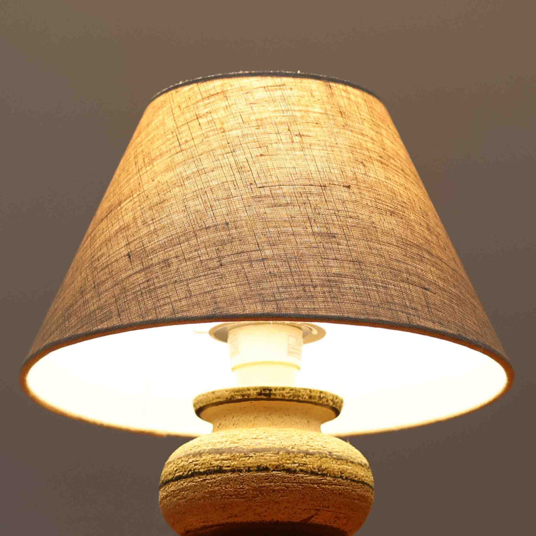 Axella製のこちらのテーブルランプは、素朴な陶土の質感と水平に重ねられた釉薬のグラデーションが生む落ち着いた佇まいが魅力で、ふくらみのある曲線的なベースと小ぶりなサイズ感が空間にさりげない温かみを添える北欧ビンテージ品です。リネンシェード越しに漏れる柔らかな灯りが陶肌の陰影をやさしく引き立て、デスクやベッドサイドなどにも取り入れやすく、経年で深まった素材の風合いが一点物ならではの味わいを感じさせてくれます。