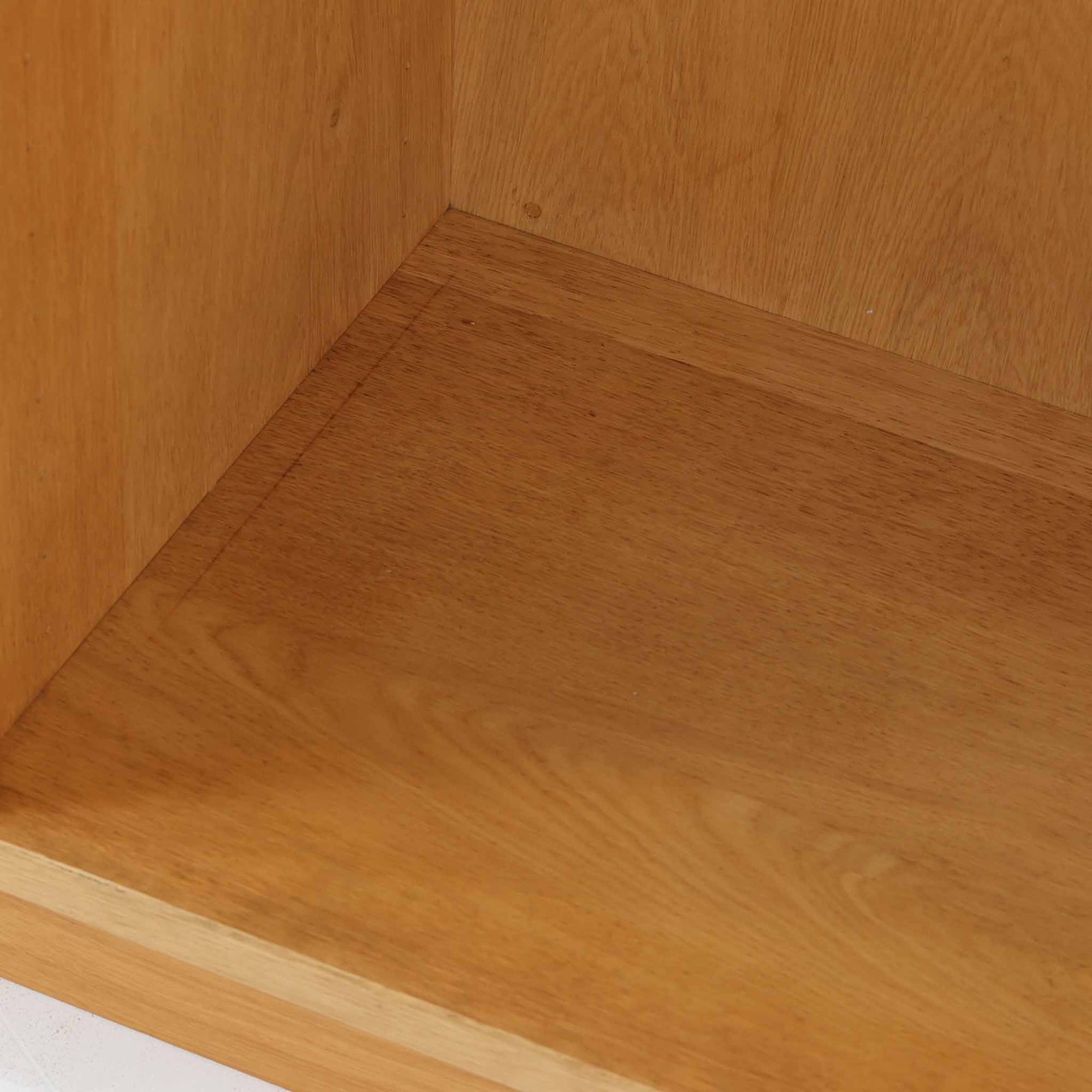 Borge Mogensenがデザインし、Karl Andersson &amp; Sonerが製作したブックシェルフです。オーク材の穏やかな木目を活かした直線的なフォルムは、無駄を削ぎ落としたモーエンセンらしい実直な美しさを感じさせます。幅135cmのゆとりあるサイズで、左右に分かれた収納部には可動棚を備え、書籍や器、オブジェまで柔軟にレイアウト可能。経年により深みを増した木肌が空間に温かみを添える、北欧ビンテージならではの堅実な一台です。