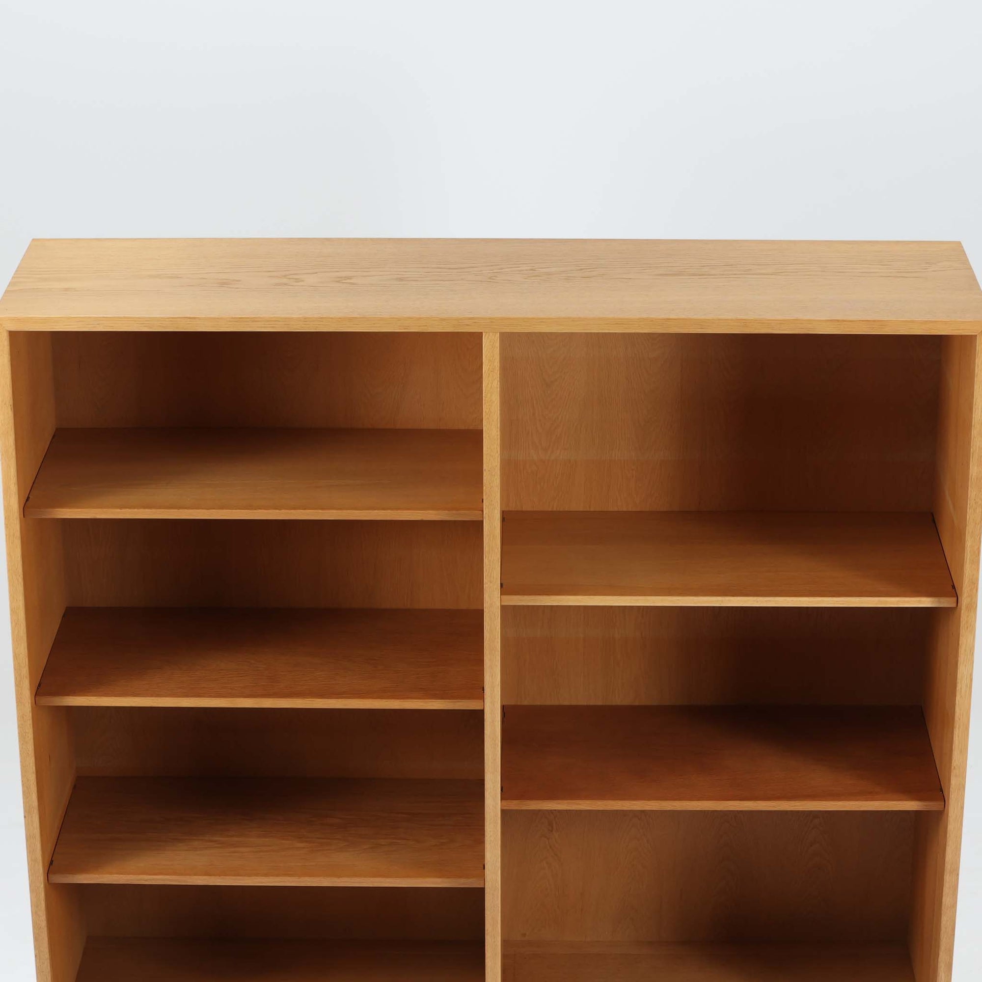 Borge Mogensenがデザインし、Karl Andersson &amp; Sonerが製作したブックシェルフです。オーク材の穏やかな木目を活かした直線的なフォルムは、無駄を削ぎ落としたモーエンセンらしい実直な美しさを感じさせます。幅135cmのゆとりあるサイズで、左右に分かれた収納部には可動棚を備え、書籍や器、オブジェまで柔軟にレイアウト可能。経年により深みを増した木肌が空間に温かみを添える、北欧ビンテージならではの堅実な一台です。
