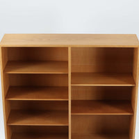 Borge Mogensenがデザインし、Karl Andersson & Sonerが製作したブックシェルフです。オーク材の穏やかな木目を活かした直線的なフォルムは、無駄を削ぎ落としたモーエンセンらしい実直な美しさを感じさせます。幅135cmのゆとりあるサイズで、左右に分かれた収納部には可動棚を備え、書籍や器、オブジェまで柔軟にレイアウト可能。経年により深みを増した木肌が空間に温かみを添える、北欧ビンテージならではの堅実な一台です。