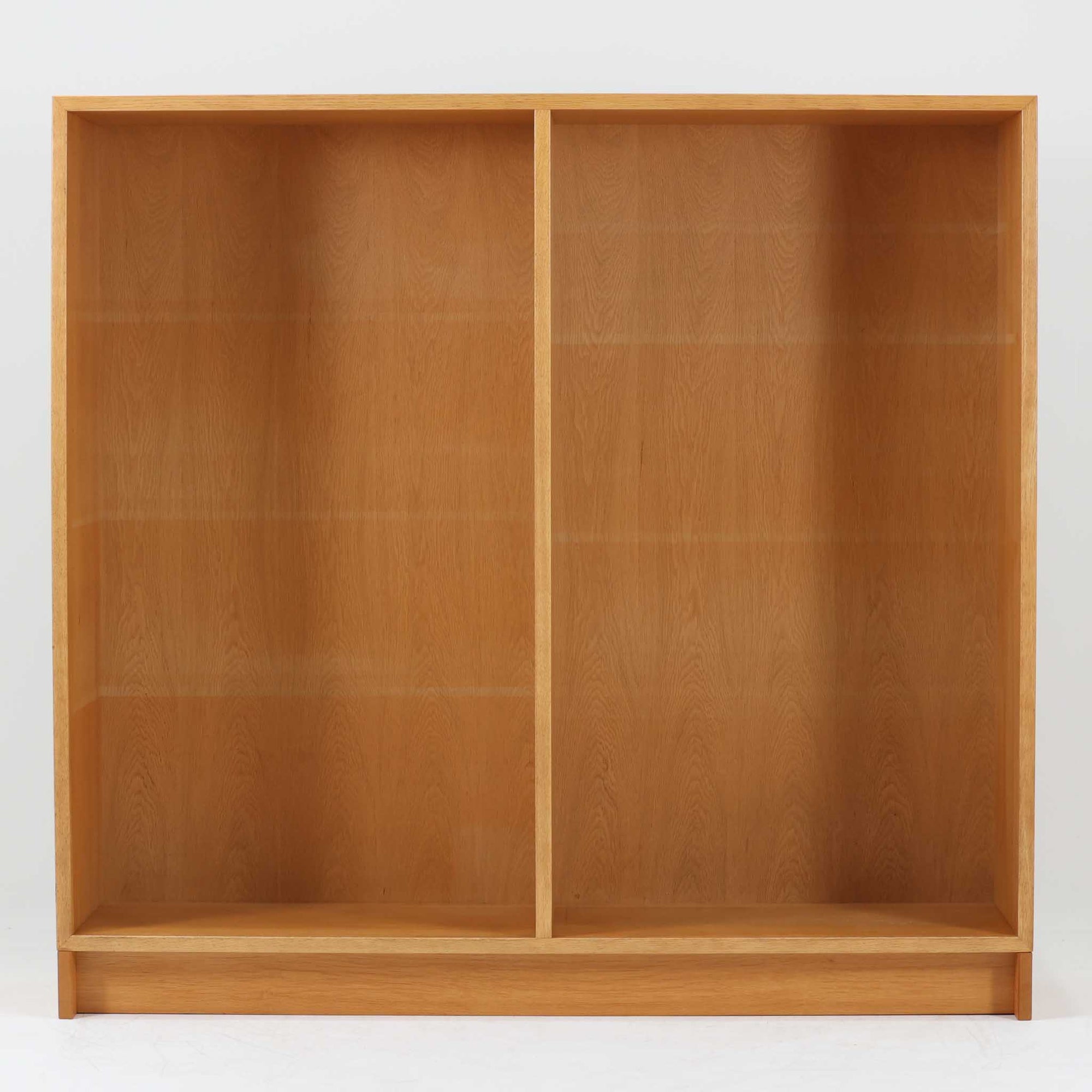 Borge Mogensenがデザインし、Karl Andersson &amp; Sonerが製作したブックシェルフです。オーク材の穏やかな木目を活かした直線的なフォルムは、無駄を削ぎ落としたモーエンセンらしい実直な美しさを感じさせます。幅135cmのゆとりあるサイズで、左右に分かれた収納部には可動棚を備え、書籍や器、オブジェまで柔軟にレイアウト可能。経年により深みを増した木肌が空間に温かみを添える、北欧ビンテージならではの堅実な一台です。