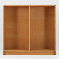 Borge Mogensenがデザインし、Karl Andersson & Sonerが製作したブックシェルフです。オーク材の穏やかな木目を活かした直線的なフォルムは、無駄を削ぎ落としたモーエンセンらしい実直な美しさを感じさせます。幅135cmのゆとりあるサイズで、左右に分かれた収納部には可動棚を備え、書籍や器、オブジェまで柔軟にレイアウト可能。経年により深みを増した木肌が空間に温かみを添える、北欧ビンテージならではの堅実な一台です。