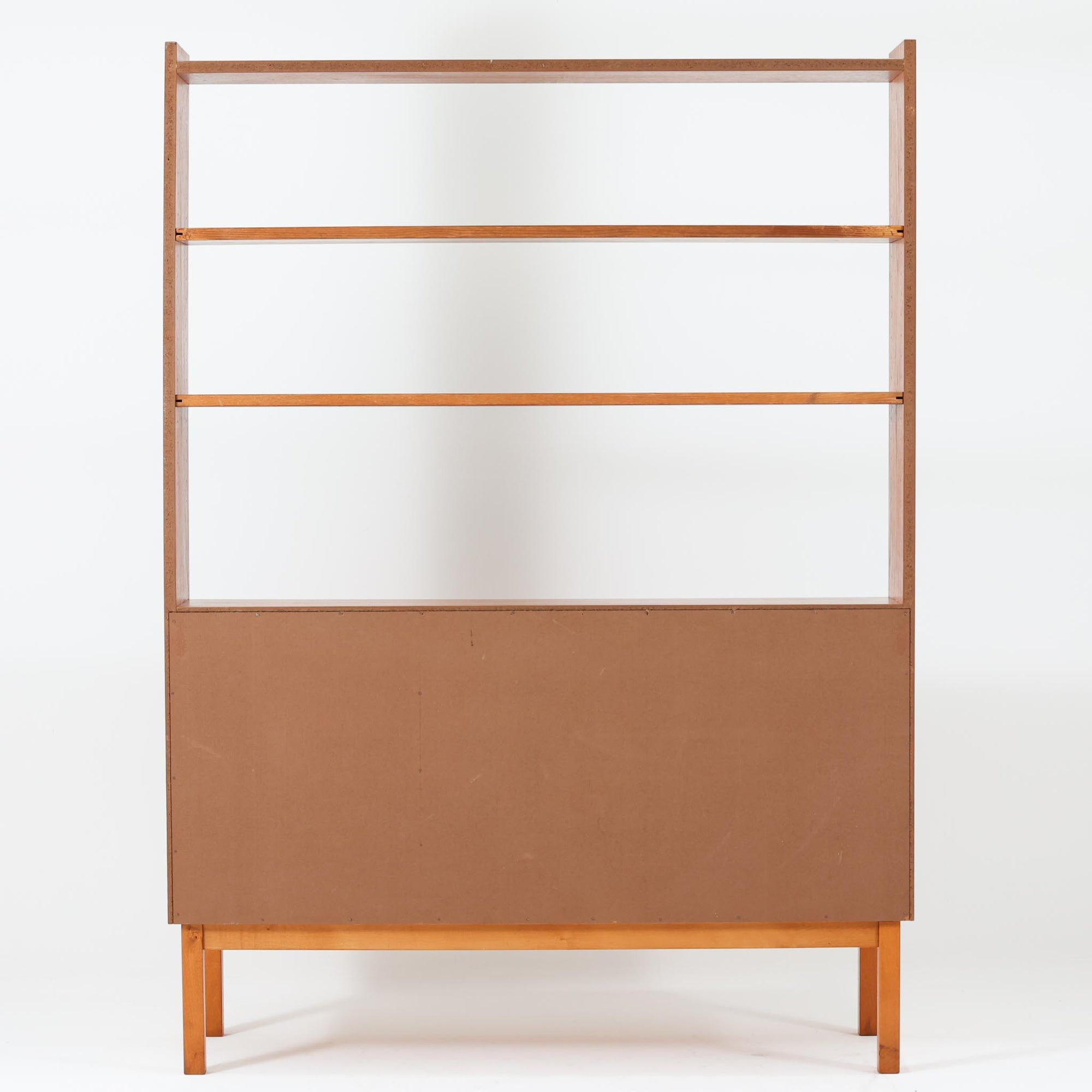 チーク材とビーチ材を組み合わせた北欧ビンテージらしい佇まいが魅力のディスプレイシェルフで、直線的で端正なフレーム構成と、木目の表情を活かした温かみのある質感が空間に落ち着きをもたらします。上部のオープン棚は器や書籍、オブジェの展示に適しており、下部には引き戸収納と引き出しを備えることで、見せる収納と隠す収納をバランス良く両立しています。脚付き構造により圧迫感が少なく、リビングやダイニング、書斎など幅広いシーンで活躍し、経年変化による色味の深まりも楽しめる一台です。