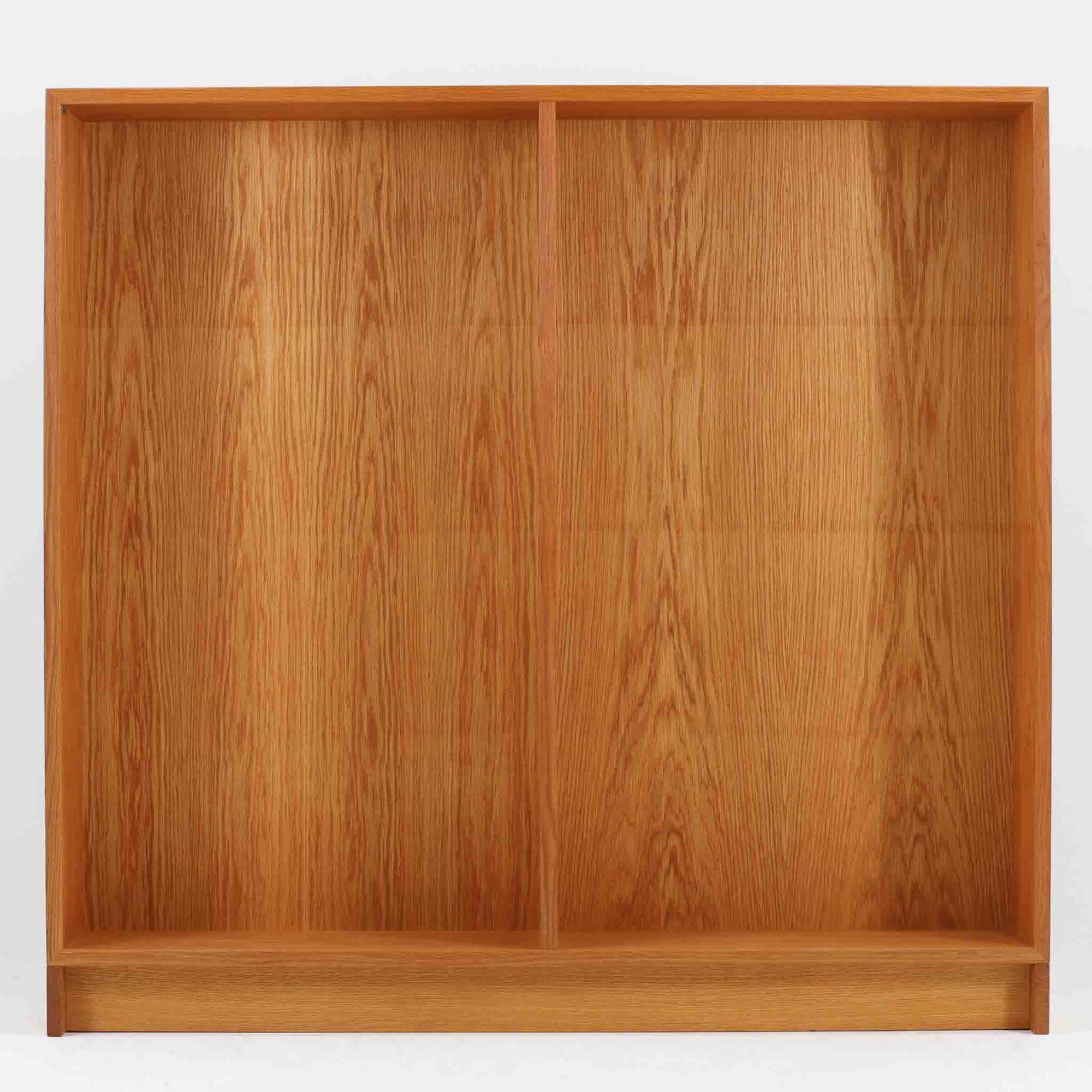 Borge Mogensenが手がけ、スウェーデンの老舗メーカーKarl Andersson &amp; Sonerより製作されたOresundシリーズのブックシェルフです。オーク材の豊かな木目を全面に活かした構成で、無駄を削ぎ落とした端正なデザインからは、日常に根ざした家具を追求したモーエンセンらしい思想が感じられます。左右に分かれた棚構造は収納力に優れ、書籍はもちろん、器やオブジェなどもバランスよく配置可能。幅135cmのゆとりあるサイズ感と安定感のある造りは、リビングや書斎の主役として空間を引き締め、経年変化によって深みを増した素材感が北欧ビンテージならではの静かな存在感を添えます。