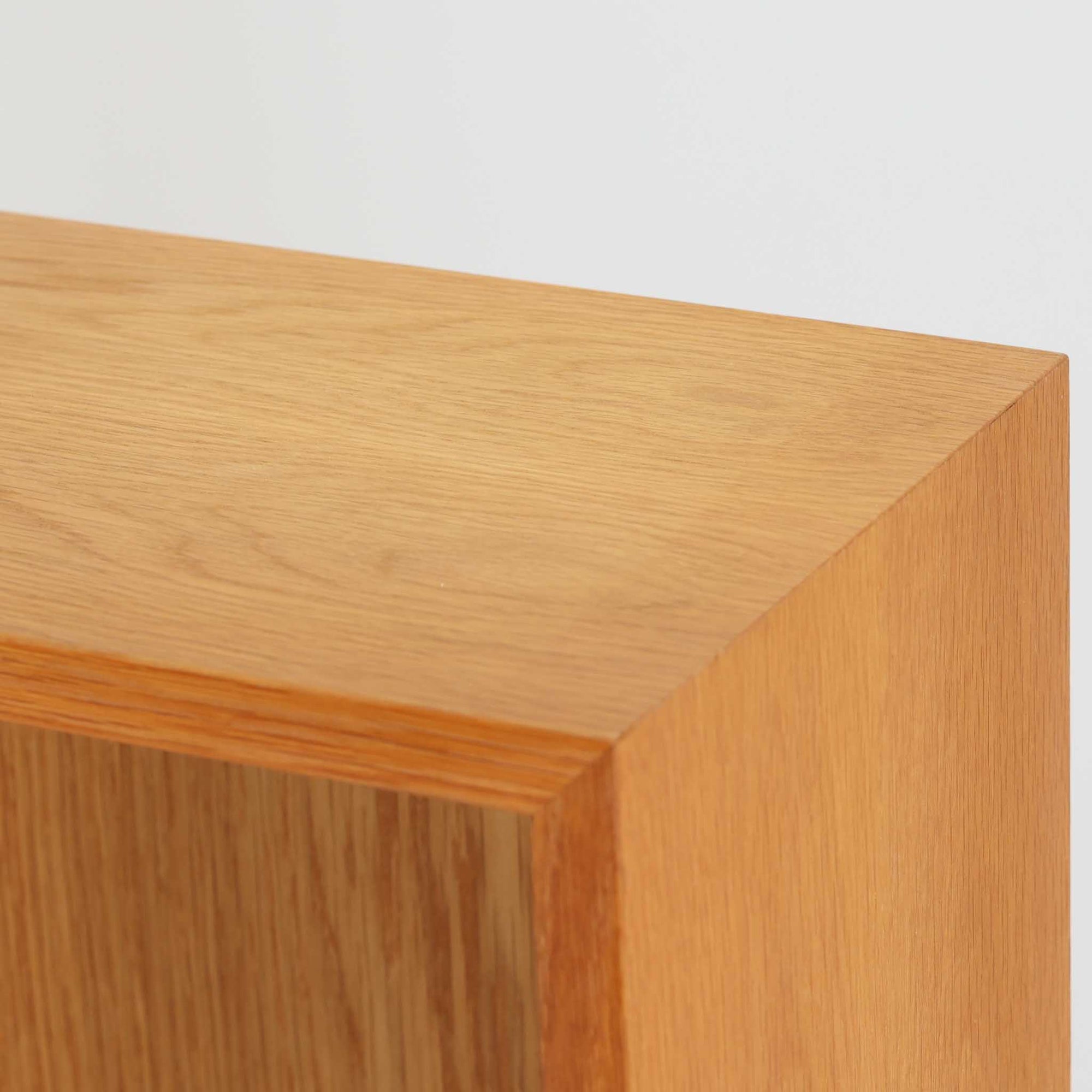 Borge Mogensenが手がけ、スウェーデンの老舗メーカーKarl Andersson &amp; Sonerより製作されたOresundシリーズのブックシェルフです。オーク材の豊かな木目を全面に活かした構成で、無駄を削ぎ落とした端正なデザインからは、日常に根ざした家具を追求したモーエンセンらしい思想が感じられます。左右に分かれた棚構造は収納力に優れ、書籍はもちろん、器やオブジェなどもバランスよく配置可能。幅135cmのゆとりあるサイズ感と安定感のある造りは、リビングや書斎の主役として空間を引き締め、経年変化によって深みを増した素材感が北欧ビンテージならではの静かな存在感を添えます。