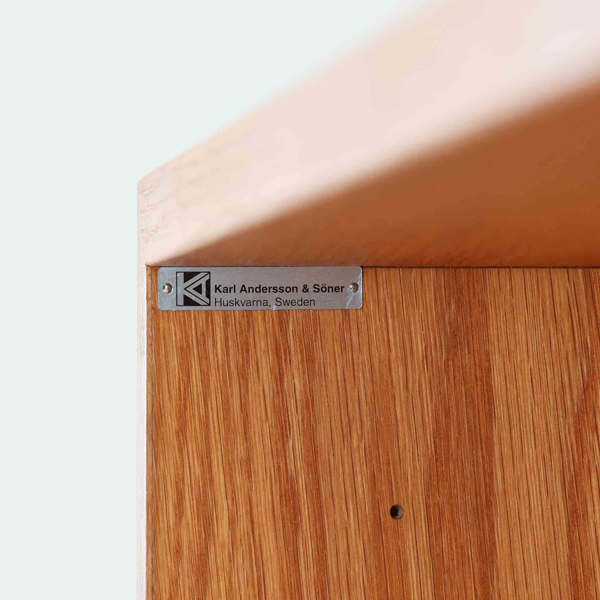 Borge Mogensenが手がけ、スウェーデンの老舗メーカーKarl Andersson &amp; Sonerより製作されたOresundシリーズのブックシェルフです。オーク材の豊かな木目を全面に活かした構成で、無駄を削ぎ落とした端正なデザインからは、日常に根ざした家具を追求したモーエンセンらしい思想が感じられます。左右に分かれた棚構造は収納力に優れ、書籍はもちろん、器やオブジェなどもバランスよく配置可能。幅135cmのゆとりあるサイズ感と安定感のある造りは、リビングや書斎の主役として空間を引き締め、経年変化によって深みを増した素材感が北欧ビンテージならではの静かな存在感を添えます。