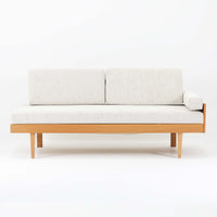 Ingmar Rellingがデザインし、EKORNESより発表されたSvane（スワン）デイベッドです。オーク材の明るく滑らかなフレームに、直線的な背もたれとすっきりとした脚部を組み合わせた端正な構造が特徴です。背もたれを上げると内部には帆布張りの収納部が備えられており、さらに背もたれを起こしてアーム部を伸ばすことでサイドテーブルとしても使用可能です。サイドテーブル部分に背クッションを載せることでベッドとしてもお使いいただけます。リビングやゲストルームなど多様な空間に適しており、張り替え済みのファブリックは上質な質感で空間にやわらかな印象を添えます。機能美と快適性を兼ね備えた、北欧ビンテージならではの名作です。