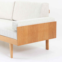 Ingmar Rellingがデザインし、EKORNESより発表されたSvane（スワン）デイベッドです。オーク材の明るく滑らかなフレームに、直線的な背もたれとすっきりとした脚部を組み合わせた端正な構造が特徴です。背もたれを上げると内部には帆布張りの収納部が備えられており、さらに背もたれを起こしてアーム部を伸ばすことでサイドテーブルとしても使用可能です。サイドテーブル部分に背クッションを載せることでベッドとしてもお使いいただけます。リビングやゲストルームなど多様な空間に適しており、張り替え済みのファブリックは上質な質感で空間にやわらかな印象を添えます。機能美と快適性を兼ね備えた、北欧ビンテージならではの名作です。