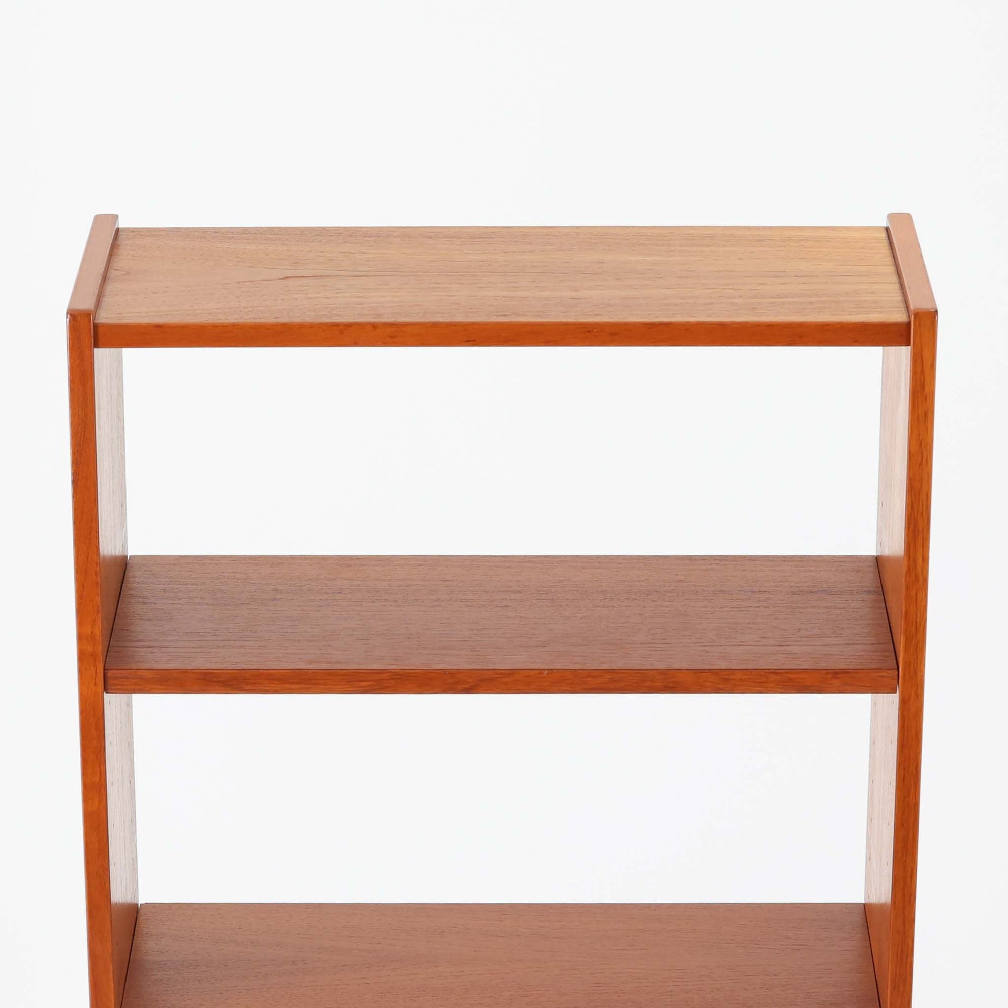 北欧ビンテージらしい機能性と造形美を備えたスリムシェルフです。チーク材のフレームにメタルを組み合わせた構造は、軽やかさと安定感を両立し、直線的で無駄のないフォルムが空間をすっきりと見せます。幅60cmの省スペース設計で、リビングや書斎、玄関まわりなど限られた場所にも取り入れやすく、書籍や小物、グリーンのディスプレイにも好適です。経年変化により深みを増したチーク材の色合いと、当時の実用性を重視した設計が、日常の暮らしに北欧らしい静かな存在感を添えます。
