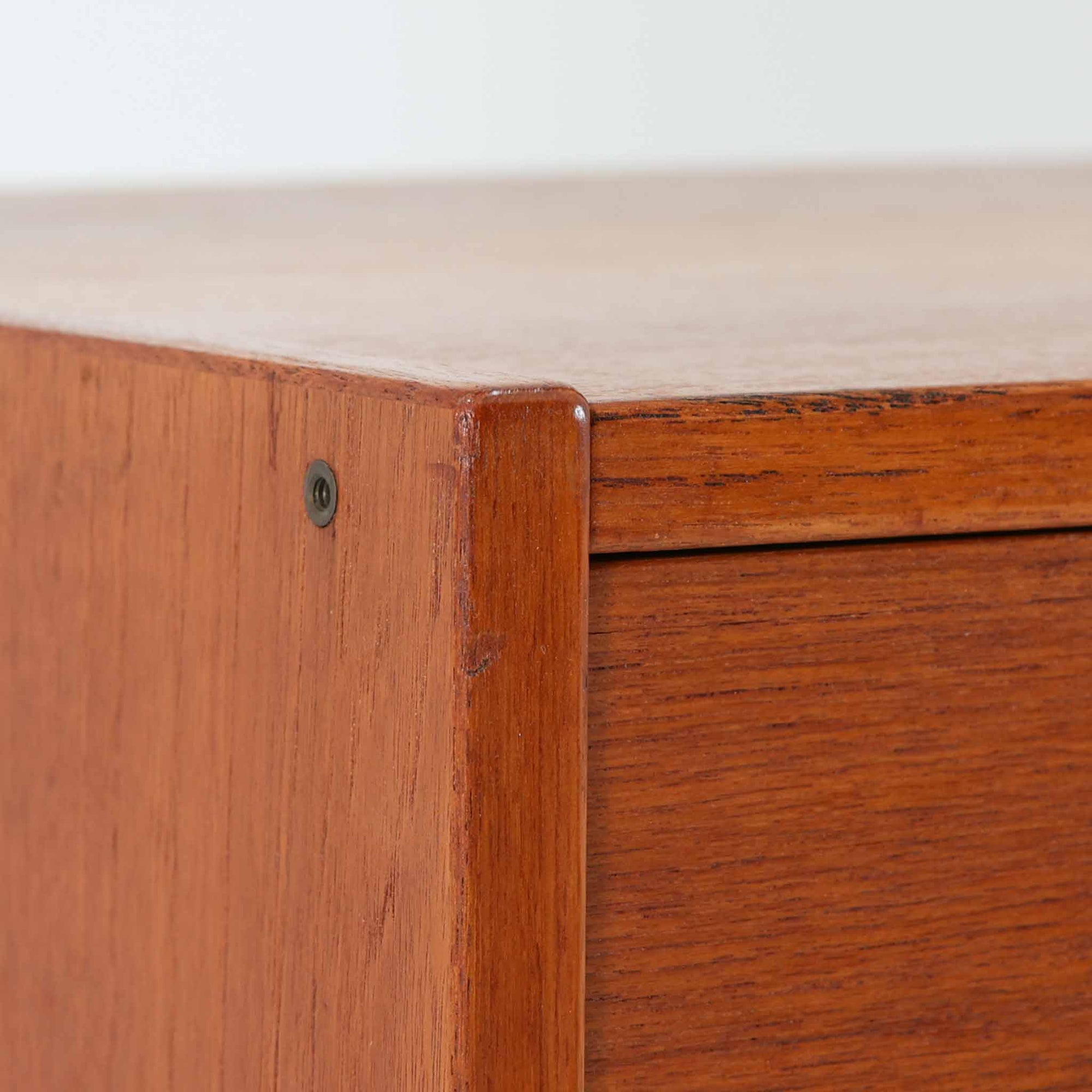 北欧ビンテージらしい機能性と造形美を備えたスリムシェルフです。チーク材のフレームにメタルを組み合わせた構造は、軽やかさと安定感を両立し、直線的で無駄のないフォルムが空間をすっきりと見せます。幅60cmの省スペース設計で、リビングや書斎、玄関まわりなど限られた場所にも取り入れやすく、書籍や小物、グリーンのディスプレイにも好適です。経年変化により深みを増したチーク材の色合いと、当時の実用性を重視した設計が、日常の暮らしに北欧らしい静かな存在感を添えます。