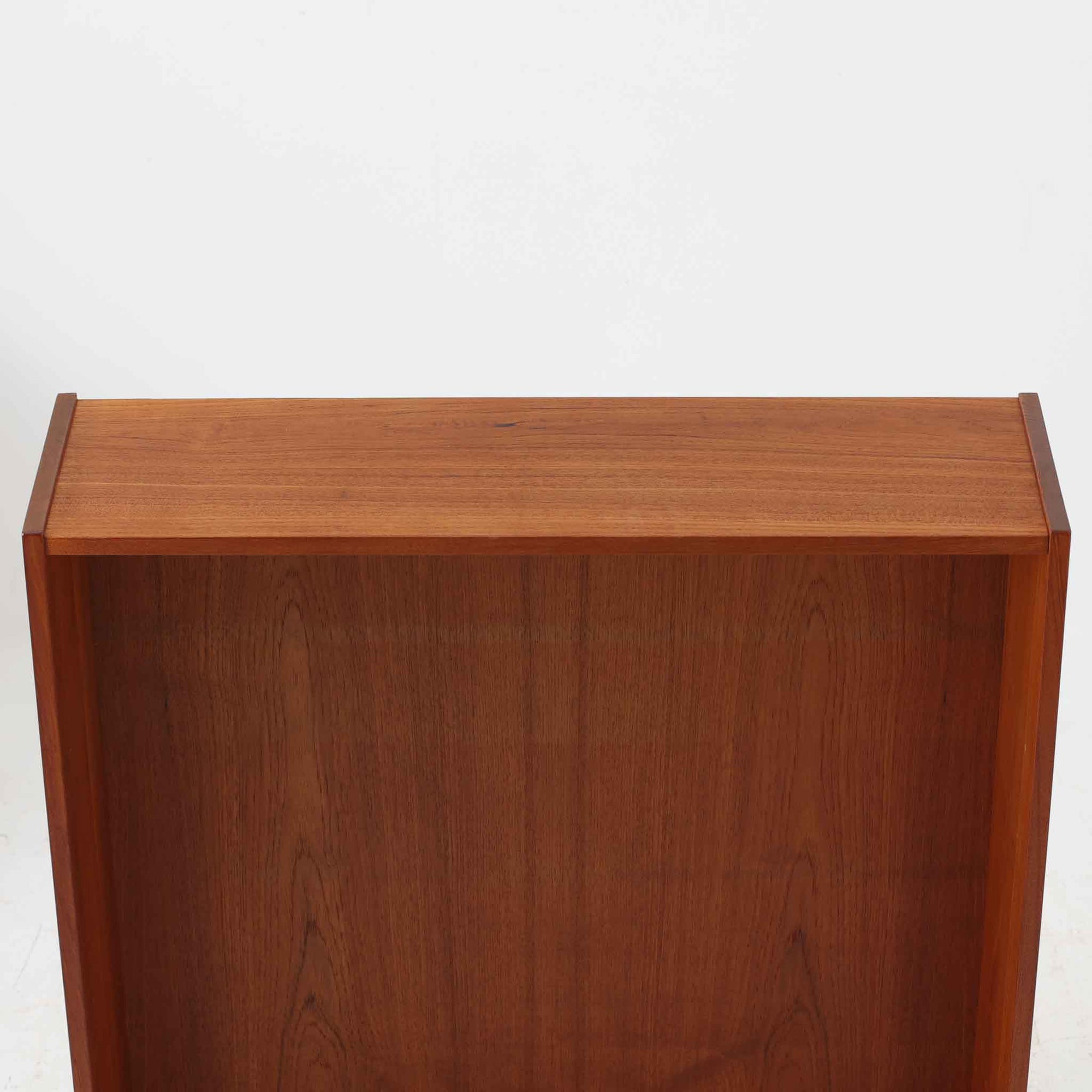 Asljunga Mobelfabrikによるディスプレイシェルフは、チーク材とビーチ材を組み合わせた端正な佇まいが魅力の北欧ビンテージ家具です。上段はオープンシェルフ構造で、棚板を活かした見せる収納が楽しめ、下段には引き戸式の収納部を備えることで実用性も確保されています。直線的で無駄のないフォルムに、掘り込み式の取っ手や脚部の軽やかなバランスが北欧らしい品の良さを添え、幅79cmの程よいサイズ感はリビングやダイニング、書斎など幅広い空間に取り入れやすく、経年変化によって深みを増した木肌と丁寧な造りが静かな存在感を放つ一台です。