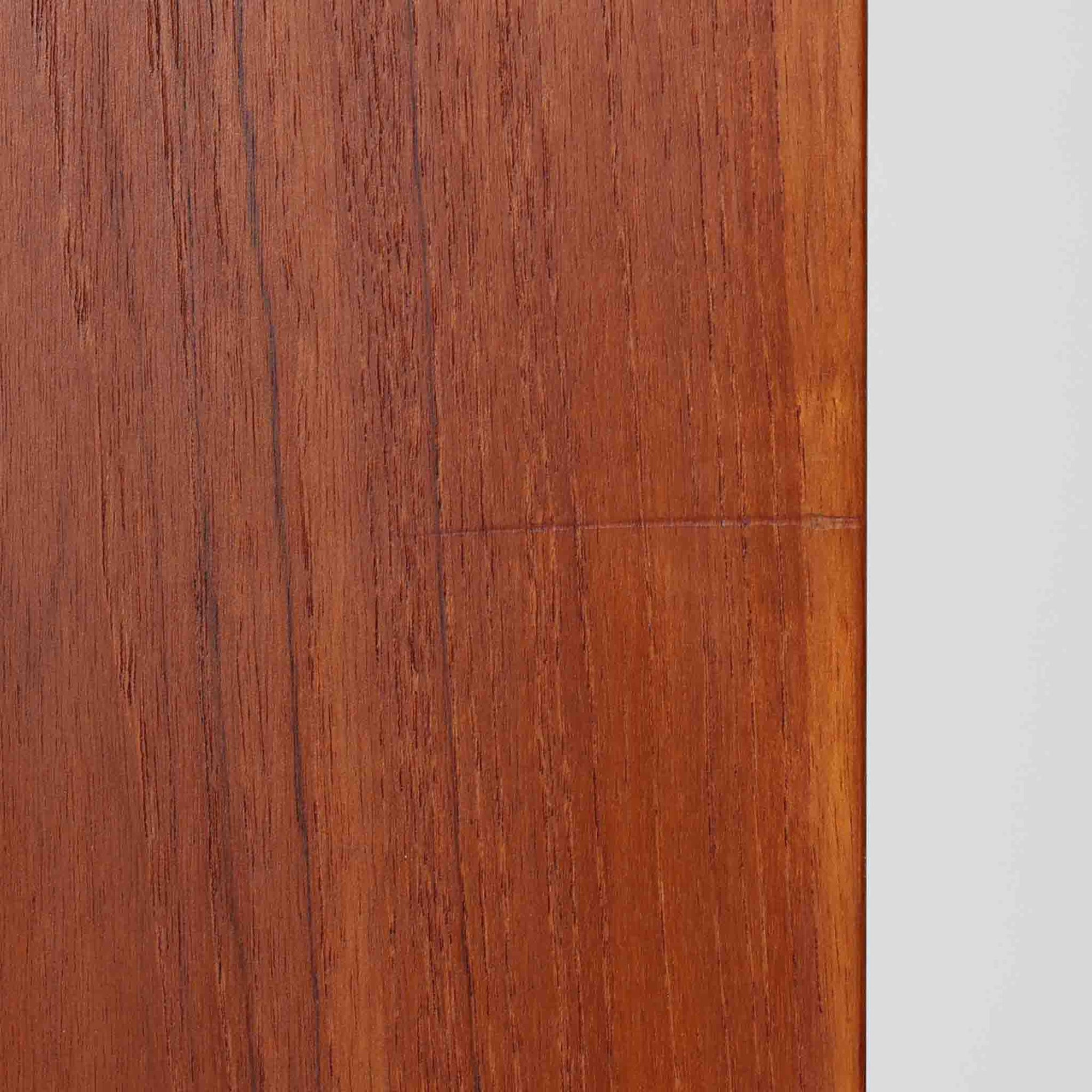 Asljunga Mobelfabrikによるディスプレイシェルフは、チーク材とビーチ材を組み合わせた端正な佇まいが魅力の北欧ビンテージ家具です。上段はオープンシェルフ構造で、棚板を活かした見せる収納が楽しめ、下段には引き戸式の収納部を備えることで実用性も確保されています。直線的で無駄のないフォルムに、掘り込み式の取っ手や脚部の軽やかなバランスが北欧らしい品の良さを添え、幅79cmの程よいサイズ感はリビングやダイニング、書斎など幅広い空間に取り入れやすく、経年変化によって深みを増した木肌と丁寧な造りが静かな存在感を放つ一台です。