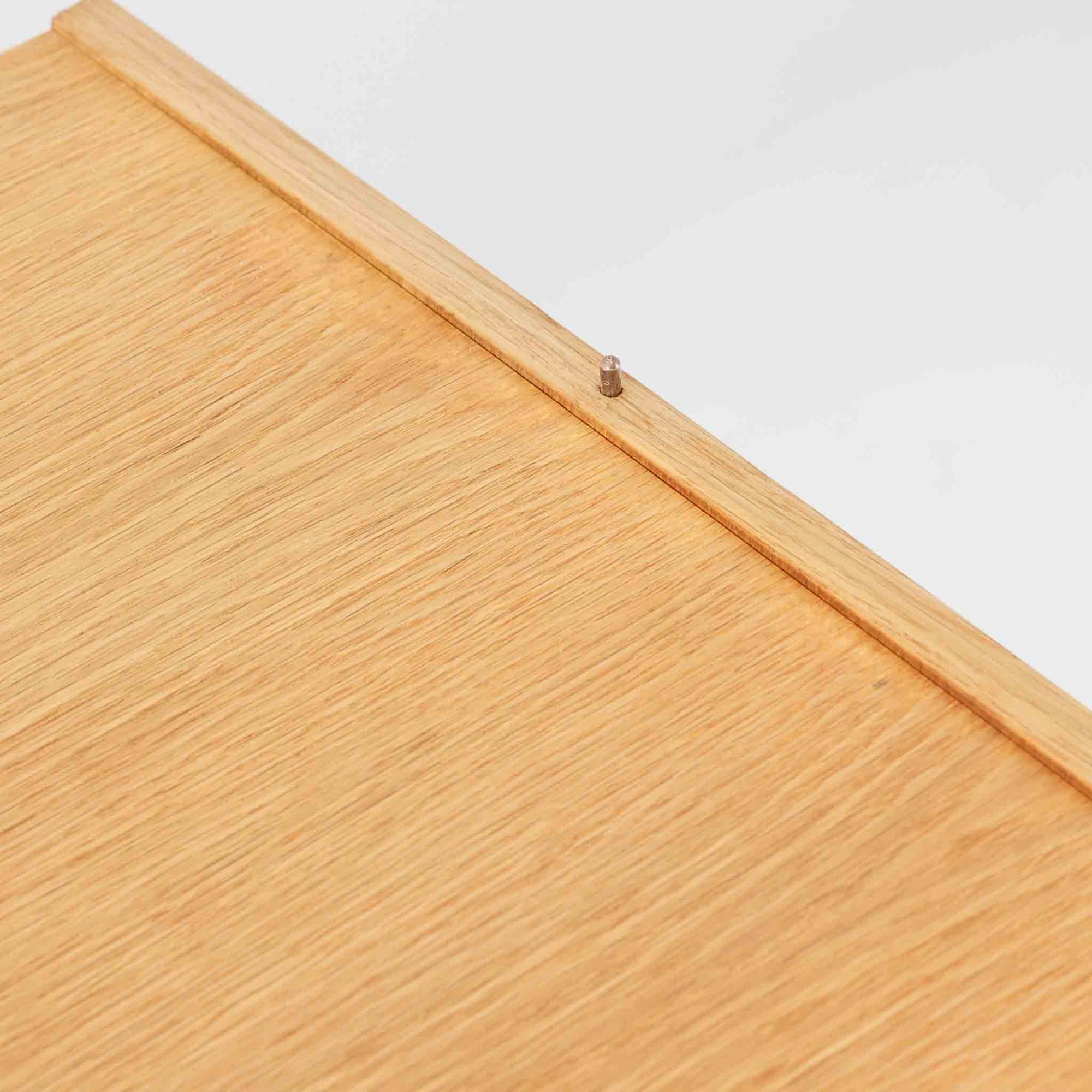 B. FridhagenがBodaforsのために手掛けたディスプレイシェルフは、端正なプロポーションと実用性を兼ね備えたスウェーデン製ビンテージ家具です。上部は抜け感のあるオープン棚構造で、器や書籍、オブジェなどを軽やかに飾ることができ、下部には4段の引き出しを備え、日常使いの収納にも対応します。オーク材ならではの明るく上品な木肌と、直線を基調とした構成が北欧らしい落ち着いた印象を生み、空間をすっきりとまとめてくれます。幅90cm、高さ122cmの小ぶりなサイズ感で、ダイニングやリビング、書斎など幅広いシーンに取り入れやすく、経年変化による木の表情も楽しめる一台です。