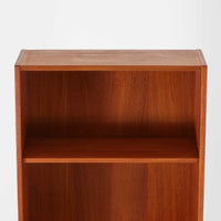 Nils Jonsson（ニールス・ヨンソン）がデザインし、Hugo Troeds（ヒューゴー・トロエッツ）社より製作されたDomi Monteシリーズのスリムシェルフです。良質なチーク材を用いた端正なキャビネットとオープンシェルフを組み合わせた構成で、収納力と見せるディスプレイ性を両立しています。直線を基調とした洗練されたフォルムと、引き出しに刻まれた繊細な手掛けが北欧らしい上品さを演出し、リビングや書斎、ダイニング収納としても活躍します。経年変化によって深みを増した木肌から、当時の職人技とビンテージならではの存在感が感じられる一台です。