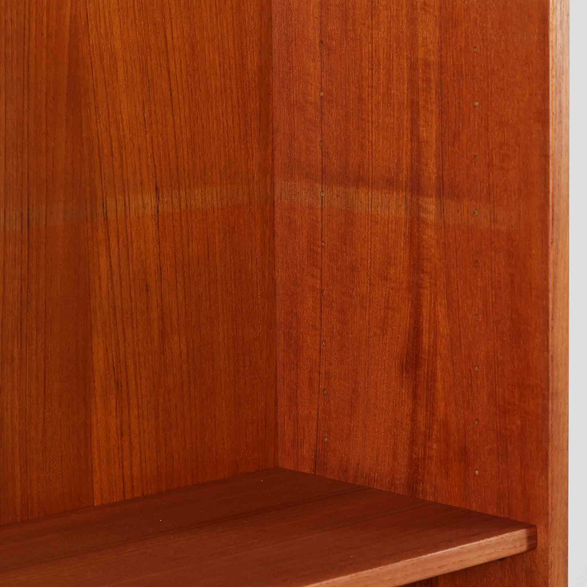 Nils Jonsson（ニールス・ヨンソン）がデザインし、Hugo Troeds（ヒューゴー・トロエッツ）社より製作されたDomi Monteシリーズのスリムシェルフです。良質なチーク材を用いた端正なキャビネットとオープンシェルフを組み合わせた構成で、収納力と見せるディスプレイ性を両立しています。直線を基調とした洗練されたフォルムと、引き出しに刻まれた繊細な手掛けが北欧らしい上品さを演出し、リビングや書斎、ダイニング収納としても活躍します。経年変化によって深みを増した木肌から、当時の職人技とビンテージならではの存在感が感じられる一台です。