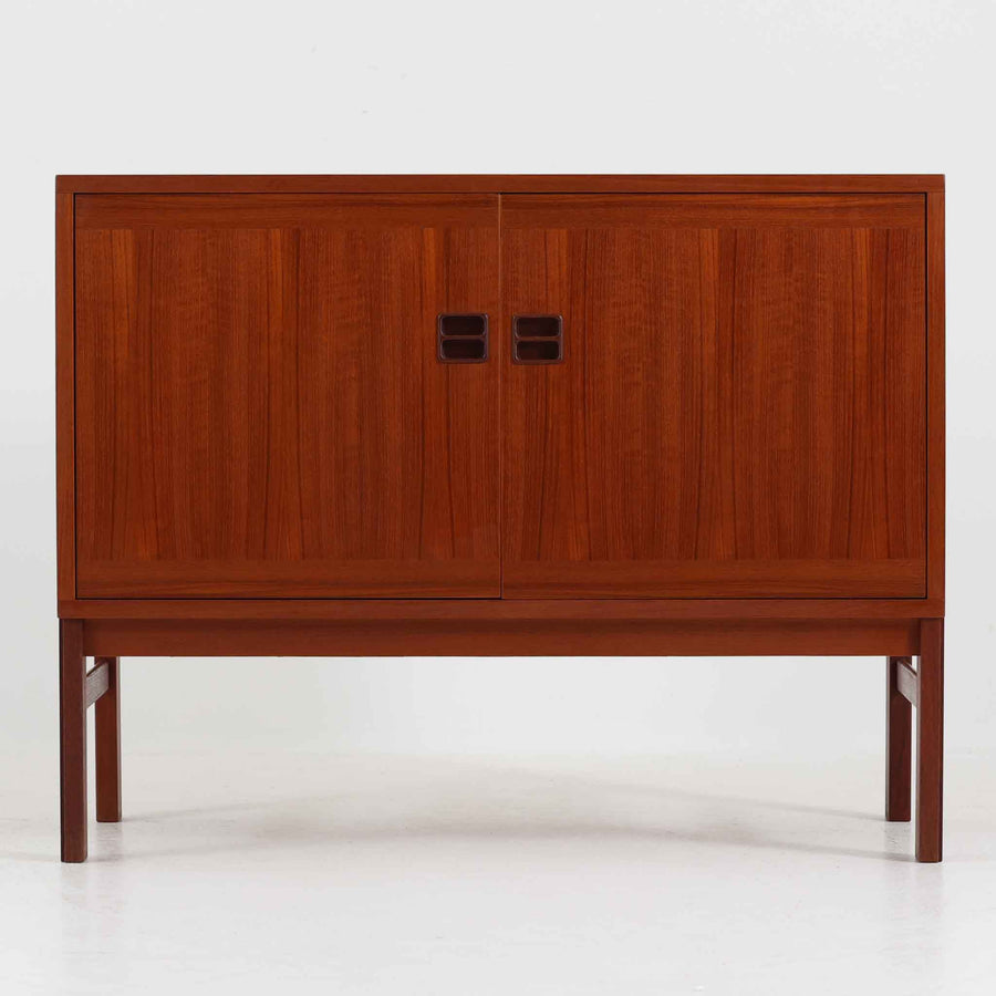 スウェーデンのデザイナー、カール・ヨハンソンによるデザイン、Bogaryds Mobler社製のチークキャビネットです。直線的なフォルムの中に、角の丸みや丁寧に仕上げられた框扉が柔らかさを添えています。チーク材の深みある色合いと美しい木目が上質な印象を与え、脚部を備えた軽快なデザインは空間に圧迫感を与えません。内部は棚板付きで収納力も高く、リビングや書斎など多用途に活躍する北欧ビンテージ家具です。