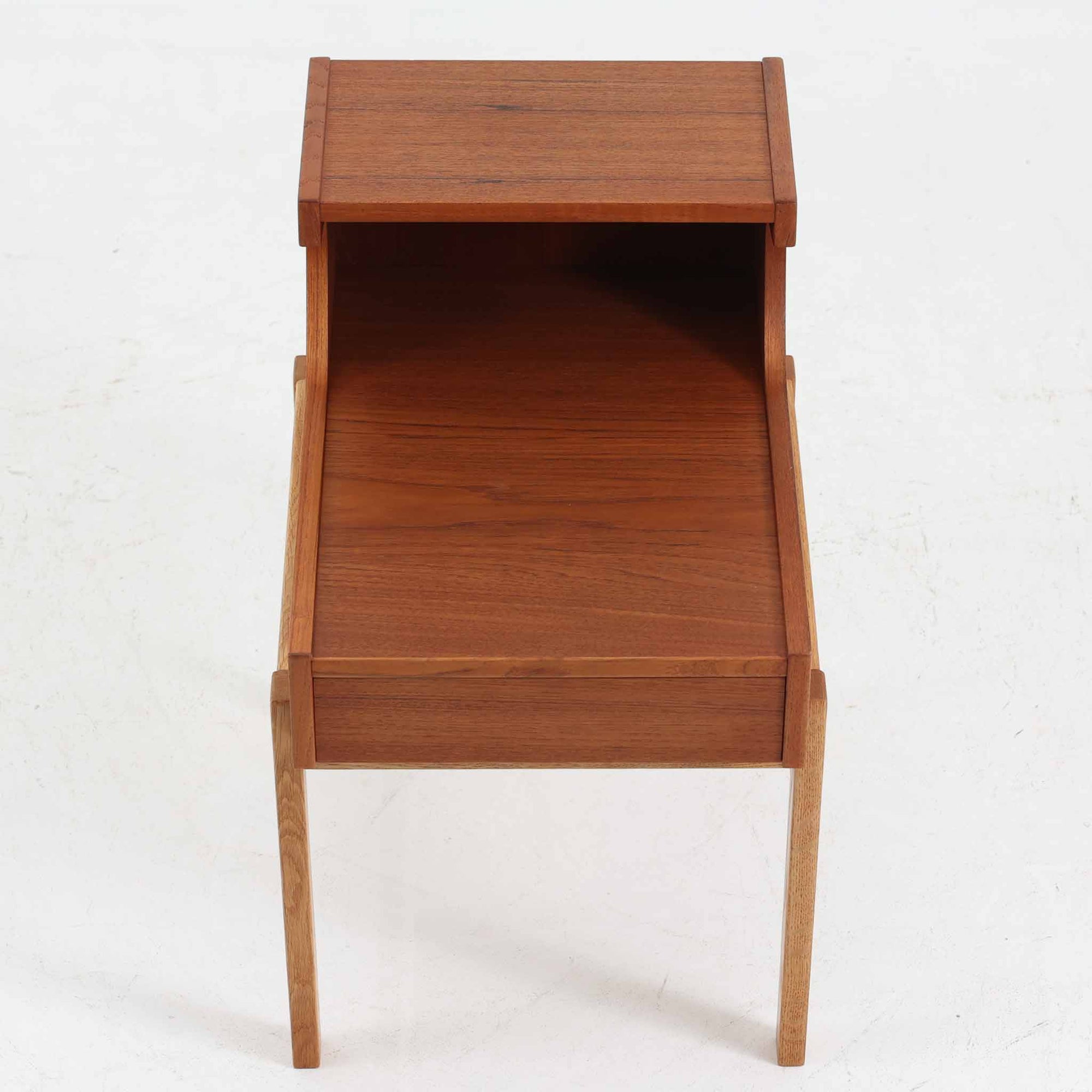 スウェーデンのGustavssons Mobelfabrik社製によるサイドチェストです。チーク材とオーク材を組み合わせたデザインで、温かみのある色合いと素材のコントラストが美しい一台です。奥行きが広く設計されており、天板スペースには照明や小物を置くことができます。緩やかなカーブを描く側面や細身の脚部が軽やかな印象を与え、寝室のナイトテーブルやリビングの補助台としても活躍します。北欧らしい洗練された職人技が光るビンテージ家具です。