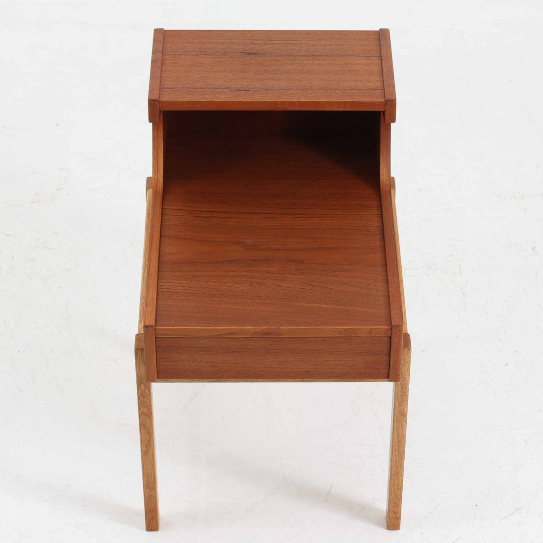 スウェーデンのGustavssons Mobelfabrik社製によるサイドチェストです。チーク材とオーク材を組み合わせたデザインで、温かみのある色合いと素材のコントラストが美しい一台です。奥行きが広く設計されており、天板スペースには照明や小物を置くことができます。緩やかなカーブを描く側面や細身の脚部が軽やかな印象を与え、寝室のナイトテーブルやリビングの補助台としても活躍します。北欧らしい洗練された職人技が光るビンテージ家具です。