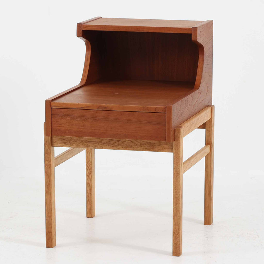 スウェーデンのGustavssons Mobelfabrik社製によるサイドチェストです。チーク材とオーク材を組み合わせたデザインで、温かみのある色合いと素材のコントラストが美しい一台です。奥行きが広く設計されており、天板スペースには照明や小物を置くことができます。緩やかなカーブを描く側面や細身の脚部が軽やかな印象を与え、寝室のナイトテーブルやリビングの補助台としても活躍します。北欧らしい洗練された職人技が光るビンテージ家具です。