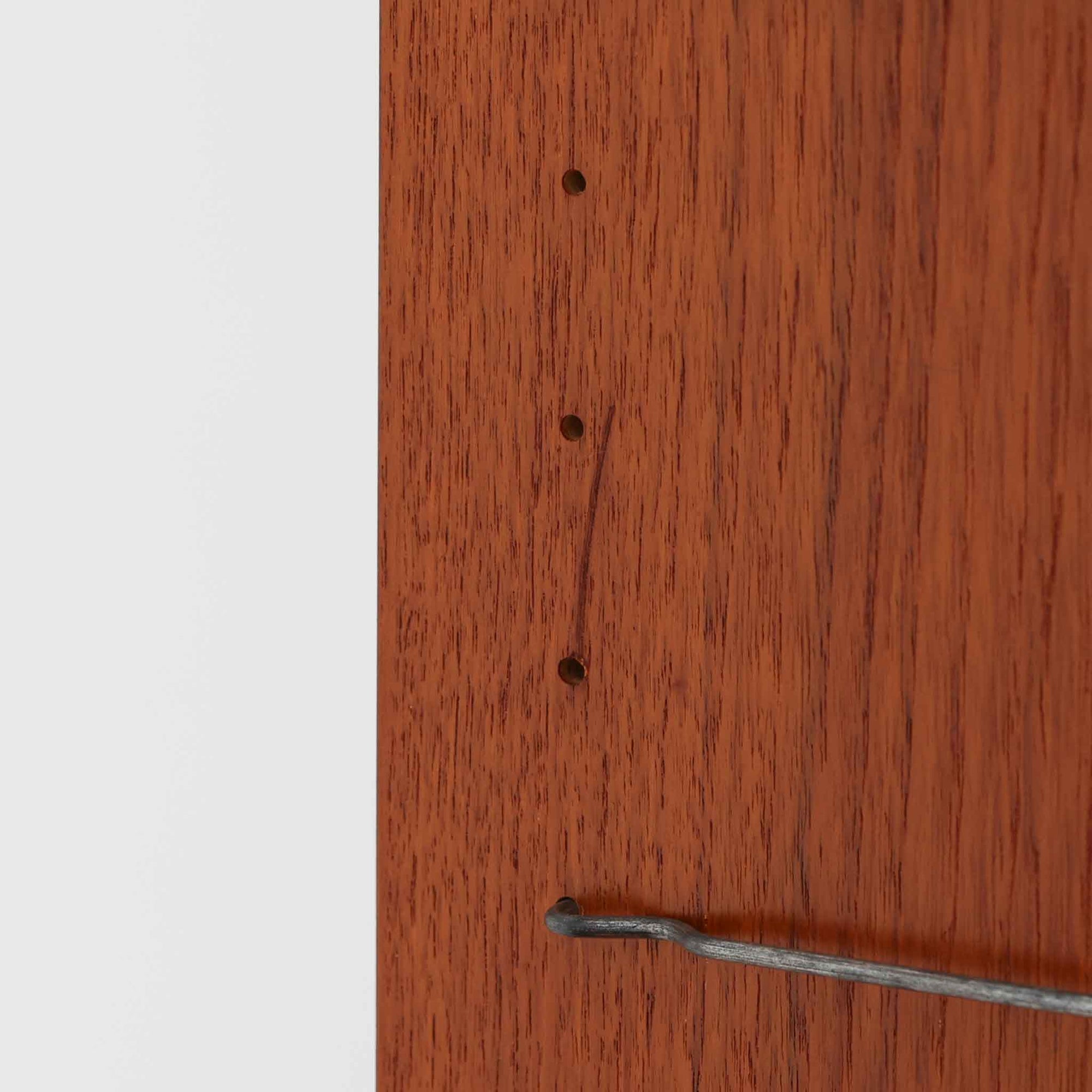 B.フリードホーゲンがデザインし、Bodafors社により製作された北欧ビンテージのディスプレイシェルフです。チーク材の美しい木目を活かした縦に伸びる端正なフレーム構成が印象的で、オープン棚と下部収納を組み合わせた実用性の高いデザインとなっています。上段は抜け感のある棚板構造で、書籍や器、オブジェを軽やかに飾ることができ、下段の引き戸収納は生活感の出やすい物をすっきりと収められます。脚付きによる軽快な佇まいと、経年変化によって深みを増した素材感が、空間に北欧ビンテージならではの落ち着いた存在感を与えます。