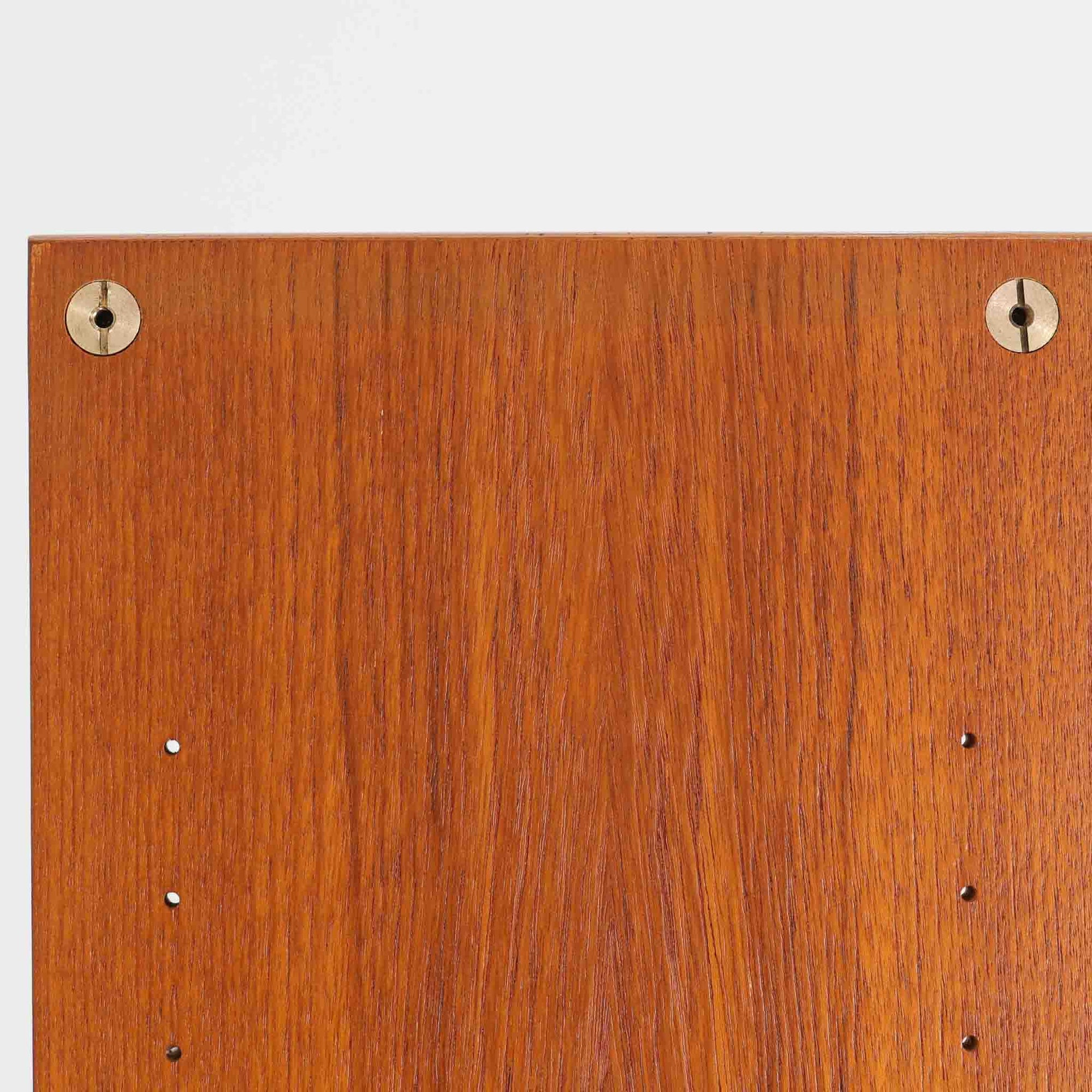 B.フリードホーゲンがデザインし、Bodafors社により製作された北欧ビンテージのディスプレイシェルフです。チーク材の美しい木目を活かした縦に伸びる端正なフレーム構成が印象的で、オープン棚と下部収納を組み合わせた実用性の高いデザインとなっています。上段は抜け感のある棚板構造で、書籍や器、オブジェを軽やかに飾ることができ、下段の引き戸収納は生活感の出やすい物をすっきりと収められます。脚付きによる軽快な佇まいと、経年変化によって深みを増した素材感が、空間に北欧ビンテージならではの落ち着いた存在感を与えます。