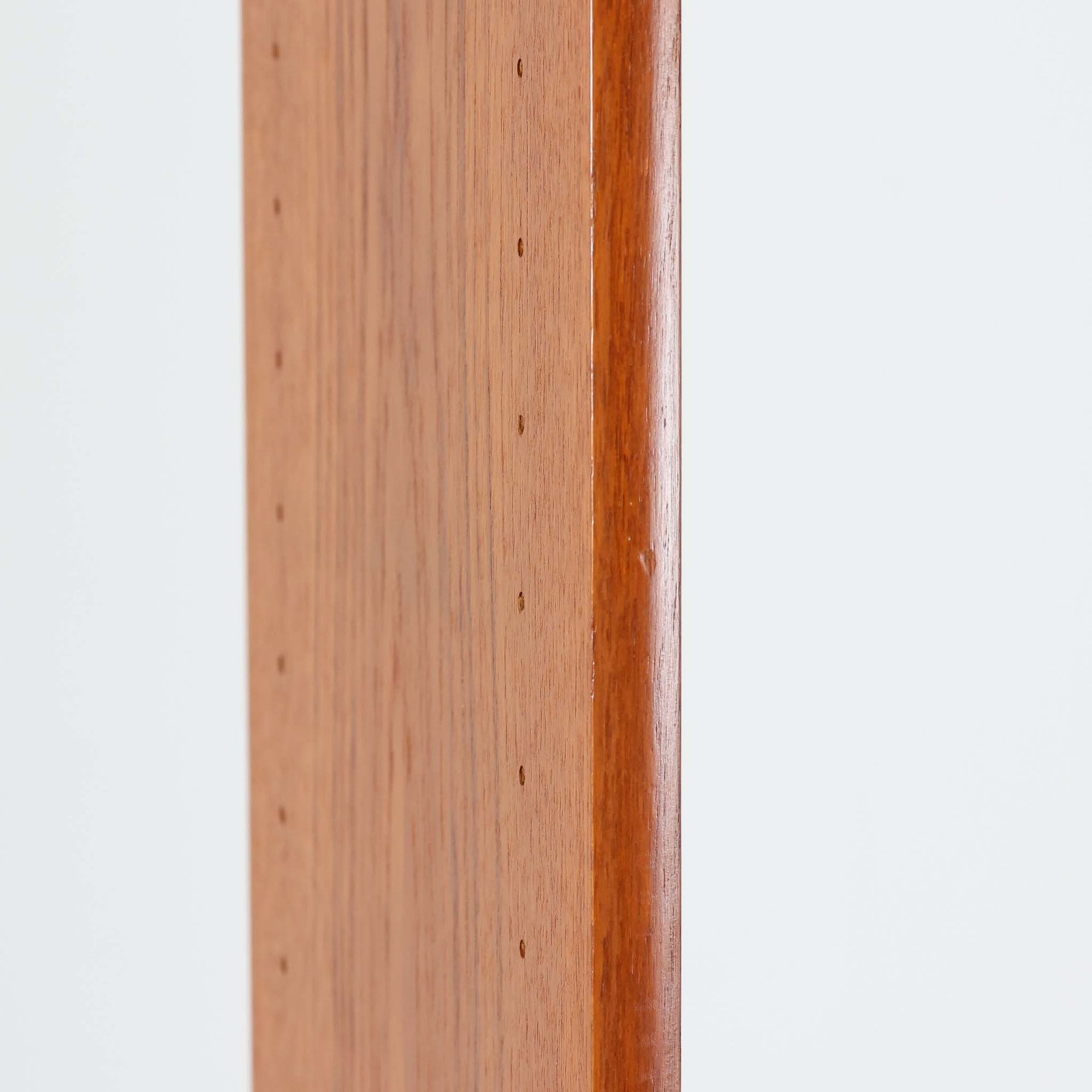 B.フリードホーゲンがデザインし、Bodafors社により製作された北欧ビンテージのディスプレイシェルフです。チーク材の美しい木目を活かした縦に伸びる端正なフレーム構成が印象的で、オープン棚と下部収納を組み合わせた実用性の高いデザインとなっています。上段は抜け感のある棚板構造で、書籍や器、オブジェを軽やかに飾ることができ、下段の引き戸収納は生活感の出やすい物をすっきりと収められます。脚付きによる軽快な佇まいと、経年変化によって深みを増した素材感が、空間に北欧ビンテージならではの落ち着いた存在感を与えます。