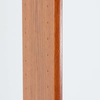 B.フリードホーゲンがデザインし、Bodafors社により製作された北欧ビンテージのディスプレイシェルフです。チーク材の美しい木目を活かした縦に伸びる端正なフレーム構成が印象的で、オープン棚と下部収納を組み合わせた実用性の高いデザインとなっています。上段は抜け感のある棚板構造で、書籍や器、オブジェを軽やかに飾ることができ、下段の引き戸収納は生活感の出やすい物をすっきりと収められます。脚付きによる軽快な佇まいと、経年変化によって深みを増した素材感が、空間に北欧ビンテージならではの落ち着いた存在感を与えます。