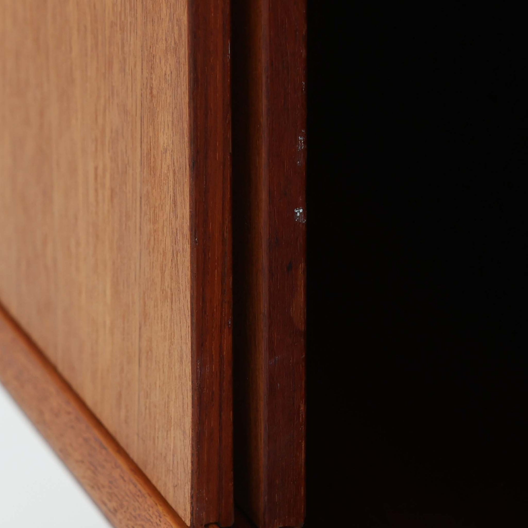 Nils Jonssonがデザインし、Hugo Troedsが製作した幅95cmの小ぶりなボードです。上質なチーク材を用いた端正な箱型フォルムに、楕円形の彫り込み取っ手がさりげないアクセントを添えています。引き戸仕様により限られた空間でも扱いやすく、内部には棚板を備え収納力も十分。すらりと伸びる脚部が軽やかな印象を与え、リビングや書斎、玄関先でも活躍します。経年により深みを増した木肌が北欧ビンテージならではの温もりと存在感を感じさせる一品です。