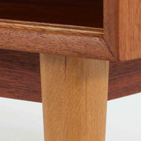 Nils Jonssonがデザインし、Hugo Troedsが製作した幅95cmの小ぶりなボードです。上質なチーク材を用いた端正な箱型フォルムに、楕円形の彫り込み取っ手がさりげないアクセントを添えています。引き戸仕様により限られた空間でも扱いやすく、内部には棚板を備え収納力も十分。すらりと伸びる脚部が軽やかな印象を与え、リビングや書斎、玄関先でも活躍します。経年により深みを増した木肌が北欧ビンテージならではの温もりと存在感を感じさせる一品です。