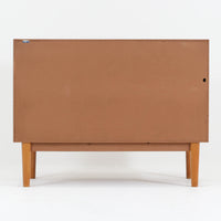 Nils Jonssonがデザインし、Hugo Troedsが製作した幅95cmの小ぶりなボードです。上質なチーク材を用いた端正な箱型フォルムに、楕円形の彫り込み取っ手がさりげないアクセントを添えています。引き戸仕様により限られた空間でも扱いやすく、内部には棚板を備え収納力も十分。すらりと伸びる脚部が軽やかな印象を与え、リビングや書斎、玄関先でも活躍します。経年により深みを増した木肌が北欧ビンテージならではの温もりと存在感を感じさせる一品です。