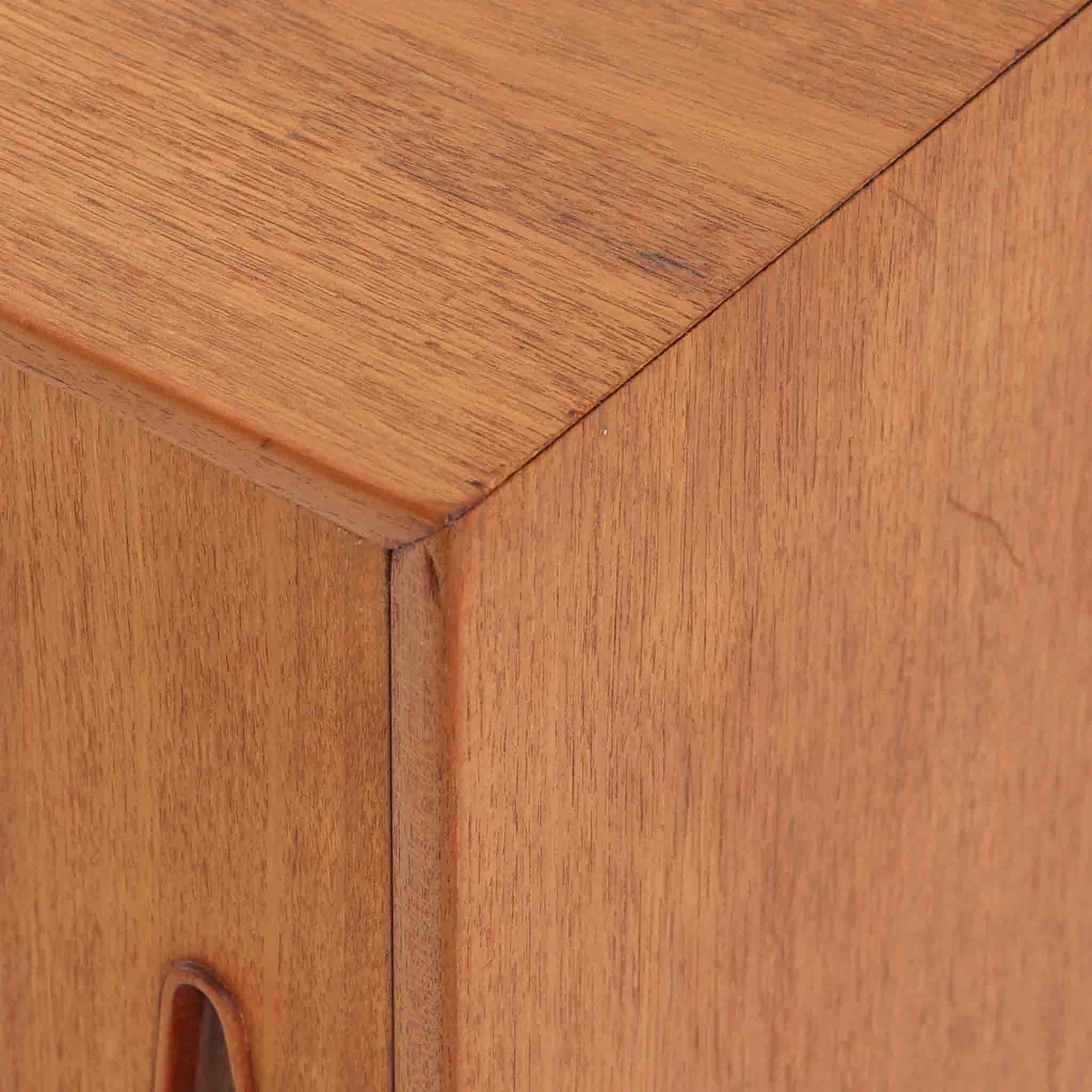 Nils Jonssonがデザインし、Hugo Troedsが製作した幅95cmの小ぶりなボードです。上質なチーク材を用いた端正な箱型フォルムに、楕円形の彫り込み取っ手がさりげないアクセントを添えています。引き戸仕様により限られた空間でも扱いやすく、内部には棚板を備え収納力も十分。すらりと伸びる脚部が軽やかな印象を与え、リビングや書斎、玄関先でも活躍します。経年により深みを増した木肌が北欧ビンテージならではの温もりと存在感を感じさせる一品です。