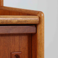 こちらのディスプレイシェルフは、チーク材とオーク材を組み合わせた柔らかなコントラストが魅力の北欧ビンテージ家具で、上部には奥行きの浅い棚板を2段備えた軽やかなディスプレイスペースに加えて天板部には引き棚が設けられており、雑貨や植物、本のレイアウトを楽しみながら作業スペースとしても活用でき、下部のスライド扉収納によって見せる収納と隠す収納を両立できるほか、細身の脚部が全体に浮遊感を与えて空間を圧迫しないバランスの良いデザインに仕上がっており、経年で深まった木肌の温もりも相まってリビングやダイニング、玄関周りにも取り入れやすい一台です。