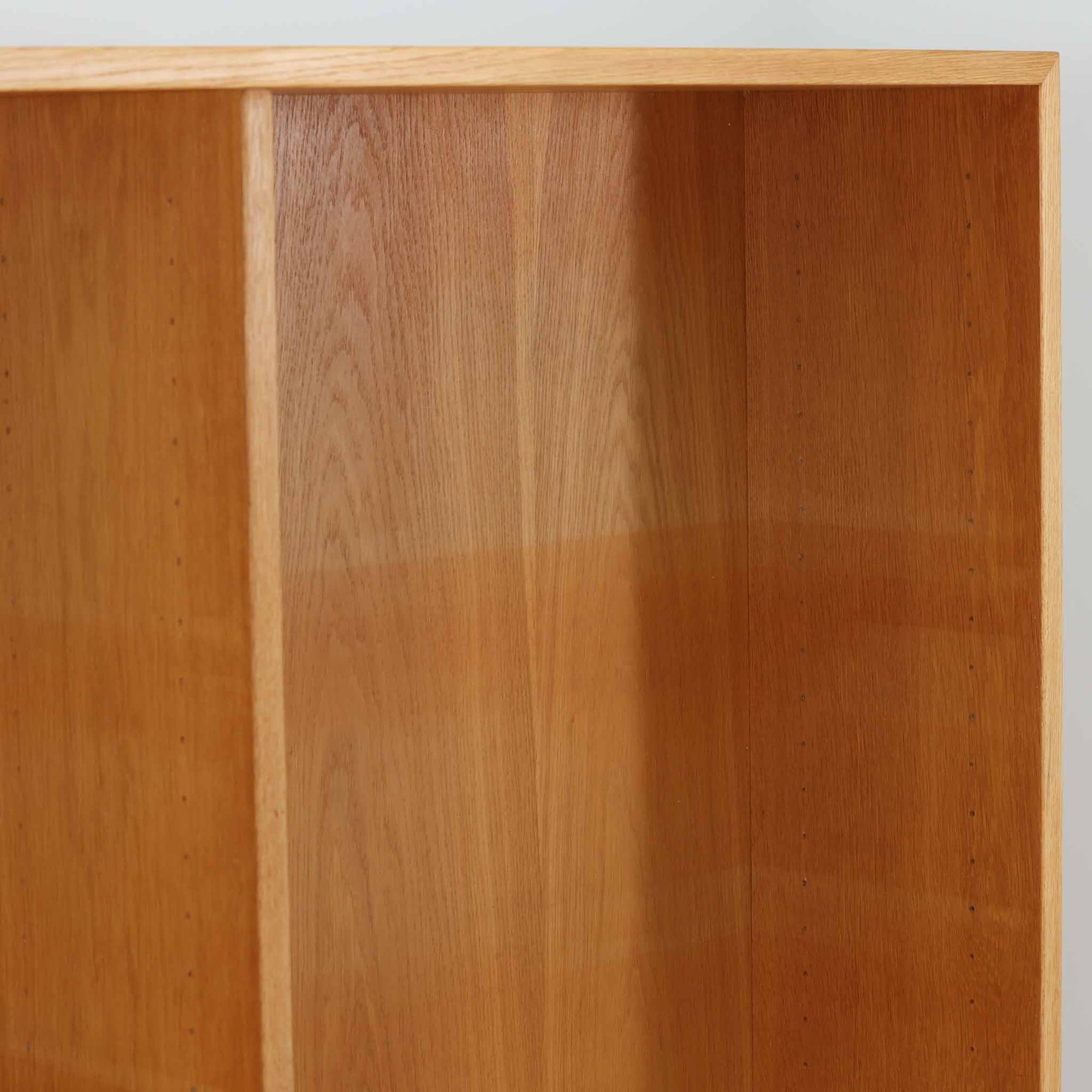 Borge Mogensenがデザインし、Karl Andersson &amp; Sonerが製作した幅135cmのブックシェルフです。上質なオーク材を用いた無駄のない直線的な構成が特徴で、中央の仕切りにより整然とした収納を実現しています。固定棚による堅牢な構造は、日常使いの書籍や資料をしっかりと支え、空間に落ち着いた存在感をもたらします。素材の質感を活かした端正な佇まいは、リビングや書斎、オフィスにも自然に馴染み、北欧ビンテージならではの実直な美しさと経年変化の魅力を感じられる一品です。