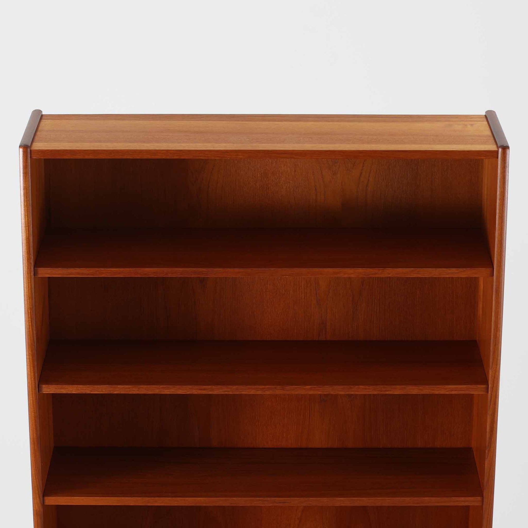 スウェーデン製のこちらのディスプレイシェルフは、チーク材の深みある木目が美しい上段のオープン棚と、下段のスライド扉収納を組み合わせた機能性の高い構成が特徴で、細身のフレームや角を丁寧に面取りした滑らかなフォルムが空間に柔らかな印象をもたらす北欧ビンテージ家具です。書籍や雑貨を見せながら収納でき、下段には日用品をすっきりと隠してしまえるため、リビングやダイニングの整理にも便利で、経年によって深まったチーク材の風合いがインテリアに温かみと落ち着きを添える一台です。