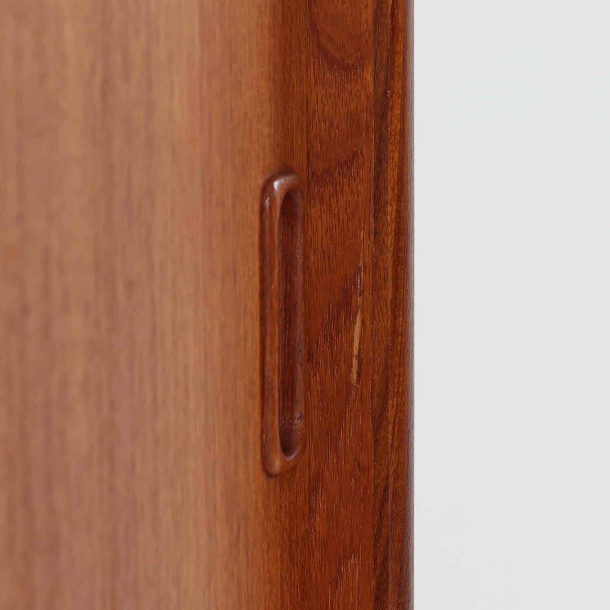 スウェーデン製のこちらのディスプレイシェルフは、チーク材の深みある木目が美しい上段のオープン棚と、下段のスライド扉収納を組み合わせた機能性の高い構成が特徴で、細身のフレームや角を丁寧に面取りした滑らかなフォルムが空間に柔らかな印象をもたらす北欧ビンテージ家具です。書籍や雑貨を見せながら収納でき、下段には日用品をすっきりと隠してしまえるため、リビングやダイニングの整理にも便利で、経年によって深まったチーク材の風合いがインテリアに温かみと落ち着きを添える一台です。