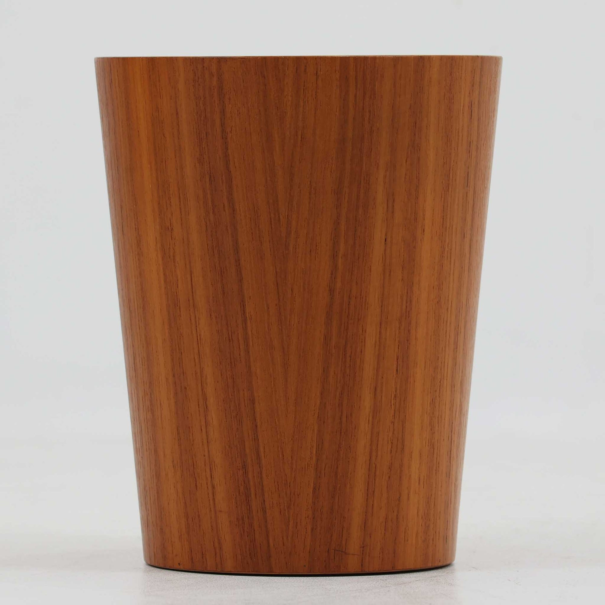 Martin Abergが手掛け、Servexで製作された「Rainbow」シリーズのペーパーバスケットは、緩やかに広がる円筒形フォルムと、木目が連続する美しい成形が印象的な一品です。成形合板ならではのしなやかな曲線と、継ぎ目を感じさせない丁寧な仕上げからは、当時の高い技術力とデザイン性がうかがえます。高さ27cmの程よいサイズ感で、デスク脇やリビング、書斎など場所を選ばず取り入れやすく、日常の中で自然に溶け込みながらも静かな存在感を放ちます。経年により深みを増した表情が、長く使い続けたくなる北欧ビンテージらしい魅力を備えています。