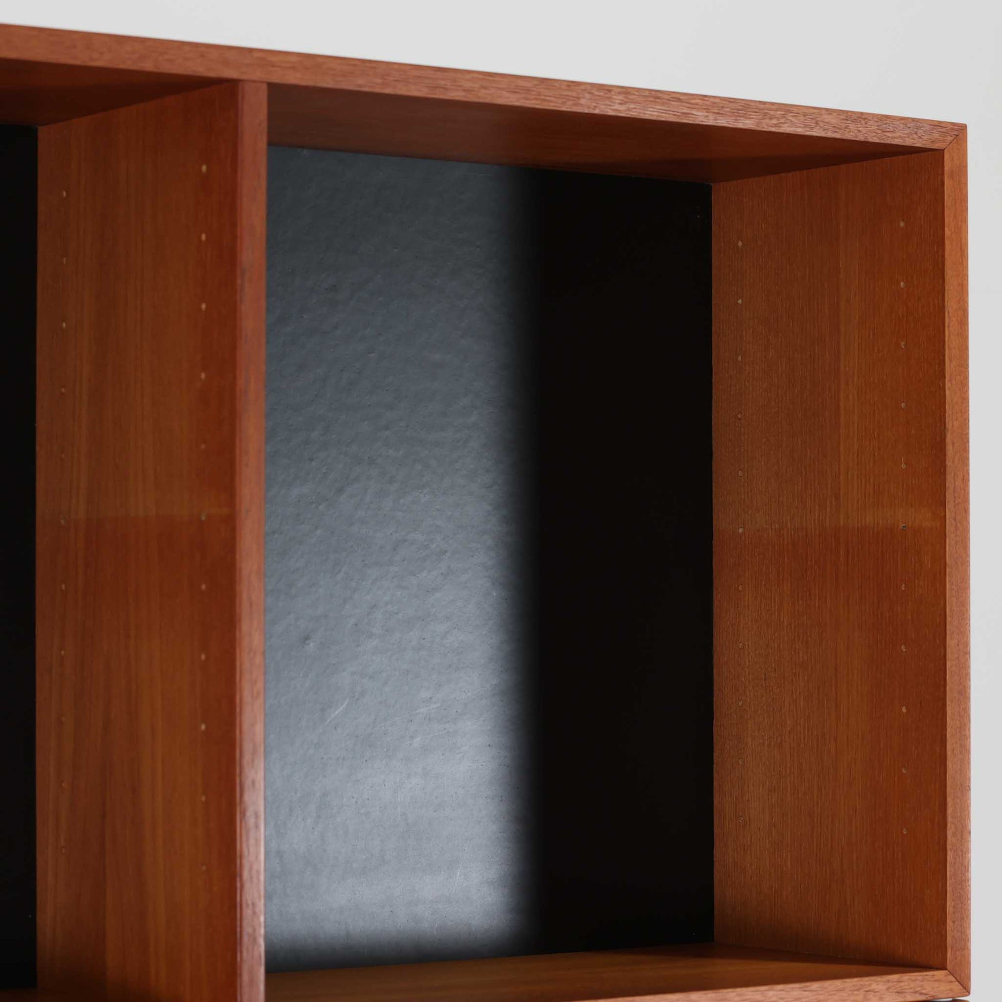 Nils Jonssonがデザインし、Hugo Troedsより発表されたモデルDomi 13のディスプレイシェルフです。チーク材の美しい木目と温かみのある色合いが空間に上質な北欧らしさをもたらします。上段・中段・下段のセクション構造で、それぞれを分けて使用できる柔軟な設計も魅力。下段は右側に引き出し、左側に高さ調整可能な棚を備え、実用性にも優れています。削り出しの取っ手や端正なフレームラインに職人技が感じられ、経年により深みを増した風合いがビンテージならではの存在感を放つ一品です。