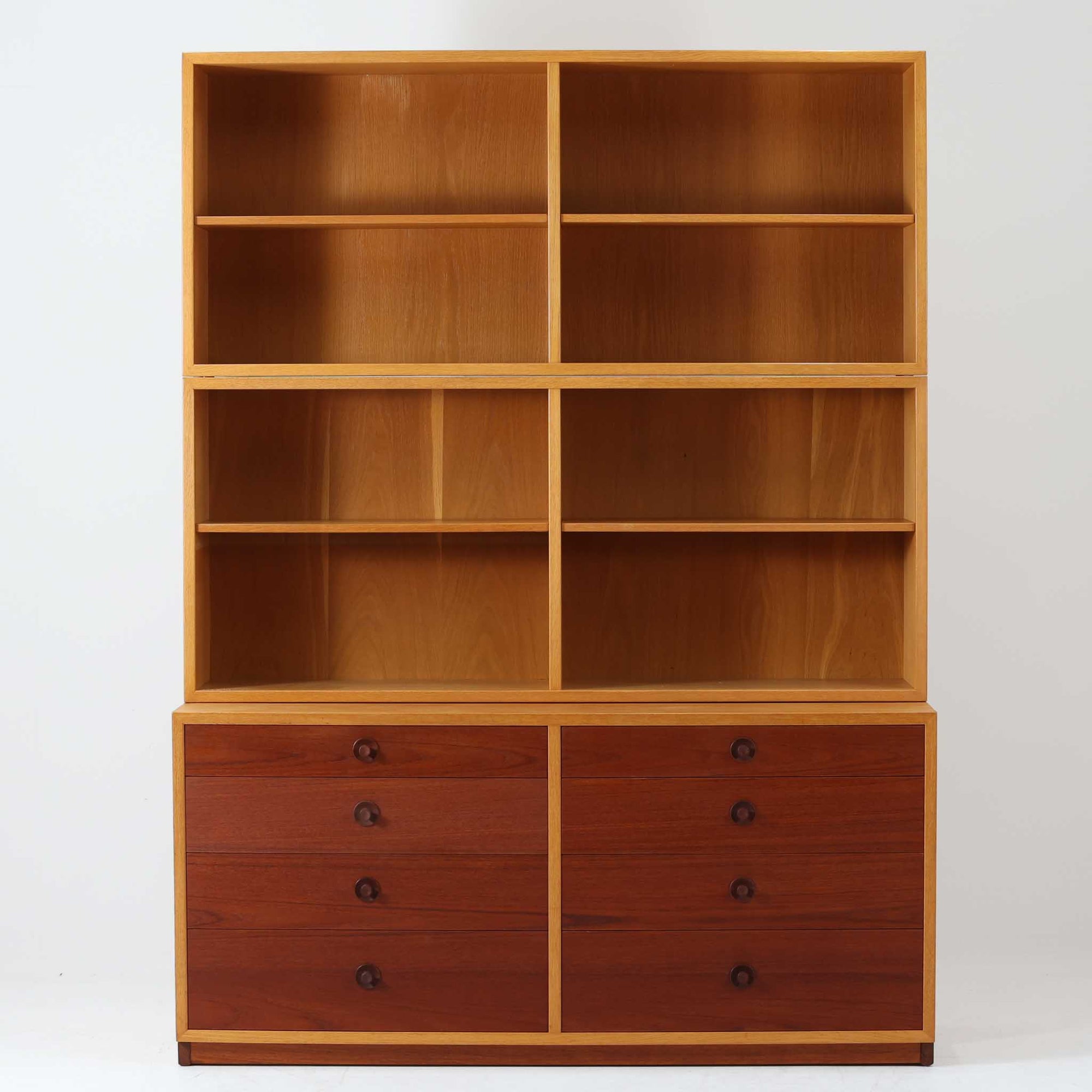 Borge Mogensenがデザインを手がけ、Karl Andersson社によって製造されたこちらのディスプレイシェルフは、チークとオークの異素材の美しいコントラストが際立つ北欧ビンテージ家具です。上段は可動式の棚板を備えたオープン収納、下段は左右に4杯ずつの引き出しを備え、収納力と機能性に優れた構成となっています。温かみのある木肌と丸型取手のアクセントが、空間に柔らかな印象を添えつつ、経年による風合いがヴィンテージらしい魅力を引き立てます。書斎やリビングでの書籍や雑貨の整理におすすめの一台です。