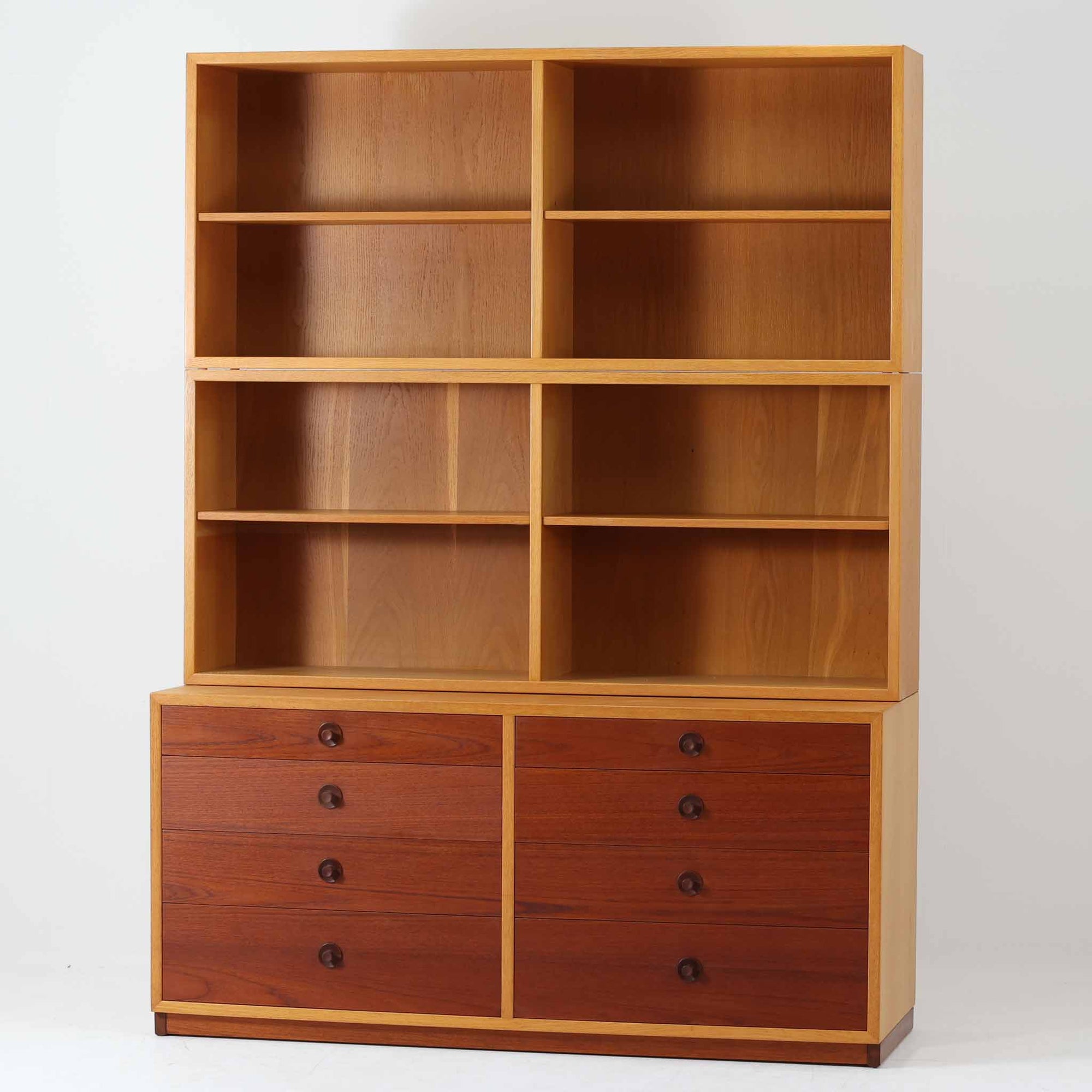 Borge Mogensenがデザインを手がけ、Karl Andersson社によって製造されたこちらのディスプレイシェルフは、チークとオークの異素材の美しいコントラストが際立つ北欧ビンテージ家具です。上段は可動式の棚板を備えたオープン収納、下段は左右に4杯ずつの引き出しを備え、収納力と機能性に優れた構成となっています。温かみのある木肌と丸型取手のアクセントが、空間に柔らかな印象を添えつつ、経年による風合いがヴィンテージらしい魅力を引き立てます。書斎やリビングでの書籍や雑貨の整理におすすめの一台です。