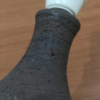 Chris HaslevがJetiのために手掛けたこちらのテーブルランプは、太陽を思わせるレリーフ模様をまとった陶器ベースと、素朴な土肌と釉薬の濃淡が織りなす豊かな表情が魅力で、コンパクトながら存在感を放つ北欧ビンテージ品です。上部のマットな質感が造形を引き締め、リネンシェード越しに広がるあたたかな灯りが空間をやさしく包み込み、リビングやベッドサイドのアクセントとして取り入れやすい一台に仕上がっています。