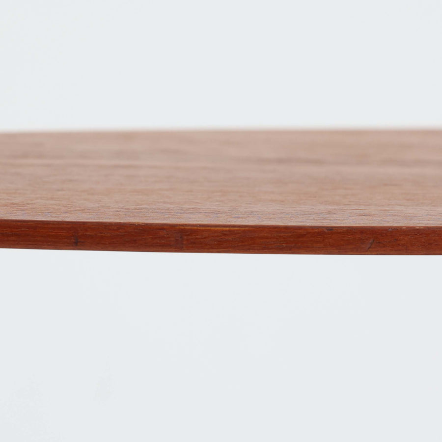 デンマーク製のチーク材サイドテーブルです。三角形に近い柔らかな曲線を描く天板と、すらりと伸びた3本脚が印象的なデザインで、ミッドセンチュリーらしい軽快な佇まいが魅力です。職人による丁寧な削り出しが際立ち、チーク材特有の深みある色合いと滑らかな手触りが楽しめます。コンパクトながら存在感があり、ソファ横やベッドサイドの小物置きとしても最適な一台です。