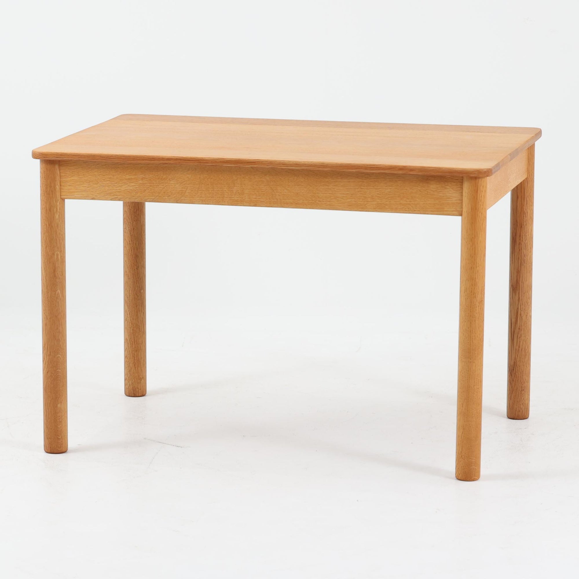 Borge Mogensenがデザインし、Fredericiaが手掛けたModel 5350 サイドテーブルです。オーク無垢材を贅沢に使用し、素材の質感を活かしたシンプルで堅牢な構造が特徴。直線を基調とした無駄のないフォルムと丸脚の柔らかな印象が調和し、モーエンセンらしい実用性と美しさを兼ね備えています。幅75cmの扱いやすいサイズで、ソファ横やベッドサイド、ちょっとした作業台としても活躍。経年により深みを増した木肌が、北欧ビンテージならではの落ち着いた存在感を空間にもたらします。