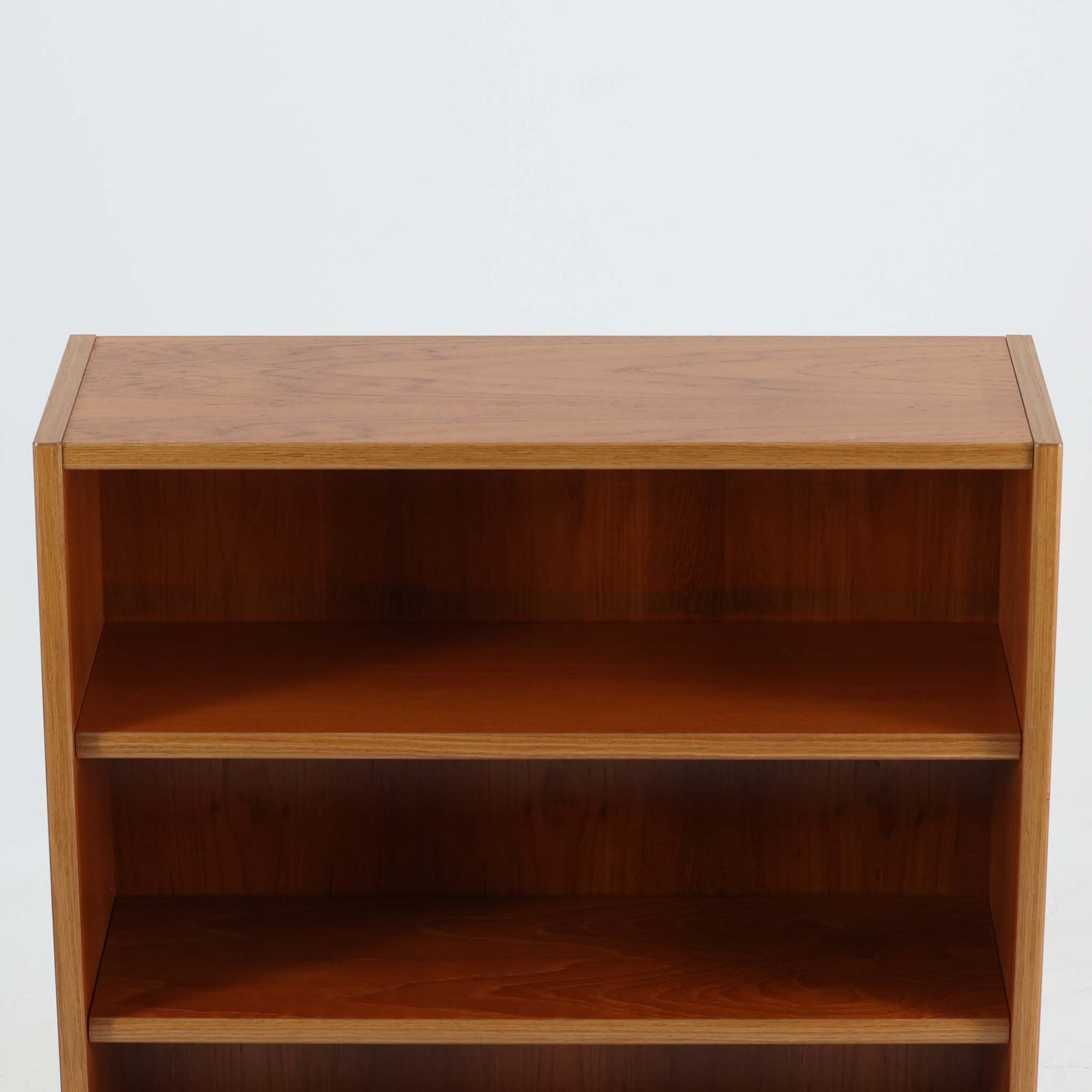 デンマーク製ブックシェルフです。小ぶりなサイズ感で扱いやすく、チーク材ならではの深みある木目と、縁にあしらわれた明るい木部のコントラストが北欧らしい端正な表情を生み出しています。無駄を削ぎ落としたシンプルな構造は圧迫感が少なく、書籍はもちろん、お気に入りの雑貨やオブジェを飾るディスプレイ棚としても活躍。リビングや寝室、デスク横にも取り入れやすく、経年で増した木肌の風合いが空間に穏やかな温もりとビンテージならではの存在感を添える一台です。