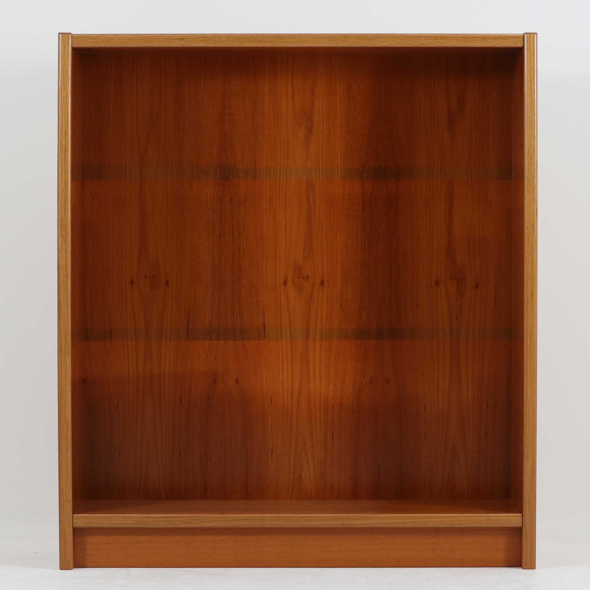 デンマーク製ブックシェルフです。小ぶりなサイズ感で扱いやすく、チーク材ならではの深みある木目と、縁にあしらわれた明るい木部のコントラストが北欧らしい端正な表情を生み出しています。無駄を削ぎ落としたシンプルな構造は圧迫感が少なく、書籍はもちろん、お気に入りの雑貨やオブジェを飾るディスプレイ棚としても活躍。リビングや寝室、デスク横にも取り入れやすく、経年で増した木肌の風合いが空間に穏やかな温もりとビンテージならではの存在感を添える一台です。
