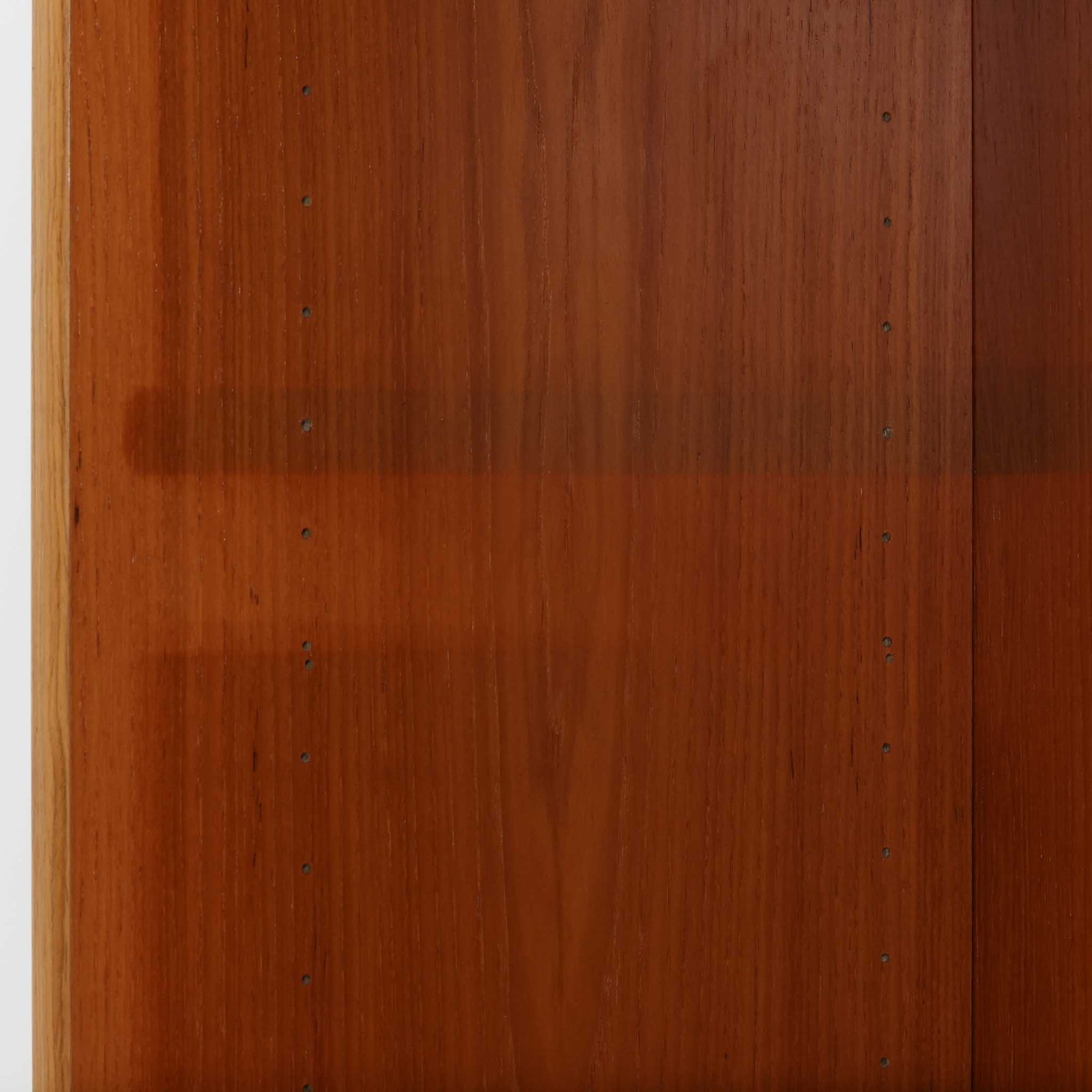 デンマーク製ブックシェルフです。小ぶりなサイズ感で扱いやすく、チーク材ならではの深みある木目と、縁にあしらわれた明るい木部のコントラストが北欧らしい端正な表情を生み出しています。無駄を削ぎ落としたシンプルな構造は圧迫感が少なく、書籍はもちろん、お気に入りの雑貨やオブジェを飾るディスプレイ棚としても活躍。リビングや寝室、デスク横にも取り入れやすく、経年で増した木肌の風合いが空間に穏やかな温もりとビンテージならではの存在感を添える一台です。