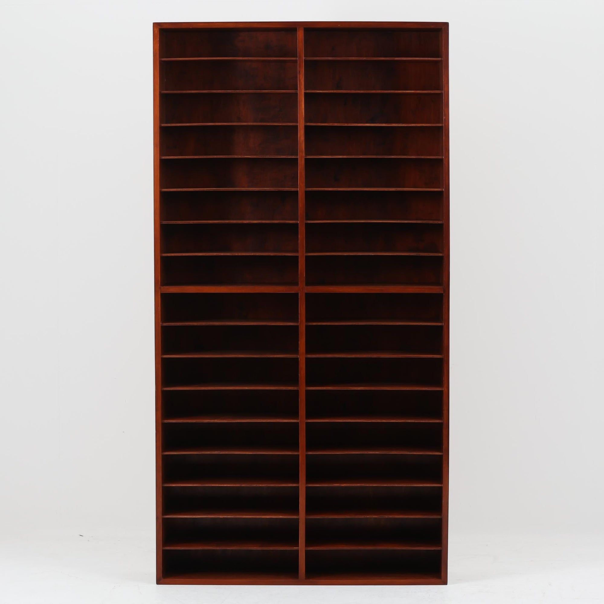 デンマーク製の書類収納シェルフです。ラワン材の深みある赤褐色の木肌を活かした端正な佇まいに、細かく区切られた棚構成が印象的で、A4書類や封筒、カタログなどを少し見せながら整然と仕分け収納できる実用性の高い一台です。縦長ながら圧迫感を抑えたすっきりとしたフォルムで、書斎やワークスペースはもちろん、ショップでの伝票整理や店舗什器としてもおすすめ。書類やペーパーアイテム、小物類を美しく並べることで、見せる収納として空間にリズムを生み出します。経年で増した木肌の艶とビンテージならではの味わいが、空間に落ち着いた存在感を添えます。