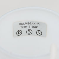 Holmegaardの「Etude」は、Michael Bang（マイケル・バング）が手掛けたガラス製のペンダントライトです。乳白色のガラスを用い、細く伸びるネックからふくらみを持たせた中央部、裾へ向かって大きく広がるシェードへと続く流麗なフォルムが印象的。存在感がありながら、ガラスならではの柔らかな光と軽やかな佇まいを楽しめます。ダイニングテーブルやリビングの主照明としても取り入れやすく、造形そのものの美しさも楽しめる北欧ビンテージ照明です。