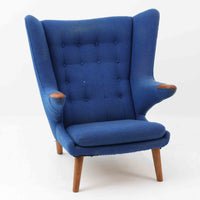 Hans J. Wegnerがデザインし、AP Stolenが製作したベアチェア AP-19 シングルソファです。包み込むように広がるハイバックと立体的なフォルムが特徴で、ゆったりと身体を預けられる快適な座り心地を生み出します。アーム先端のチーク材の滑らかな質感とオーク材の脚部による安定感のある構造が、美しいコントラストと上質な存在感を演出。張地内部にはビンテージ特有のスプリングが内包され、程よい弾力が寛ぎの時間をより豊かにします。空間の主役として北欧デザインの魅力を存分に味わえる一脚です。